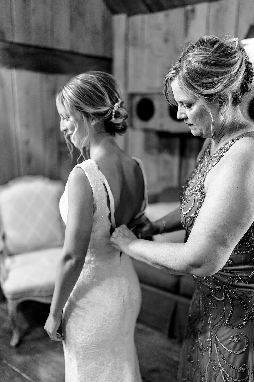 mom helping the bride get her dress on at Frutig Farms 