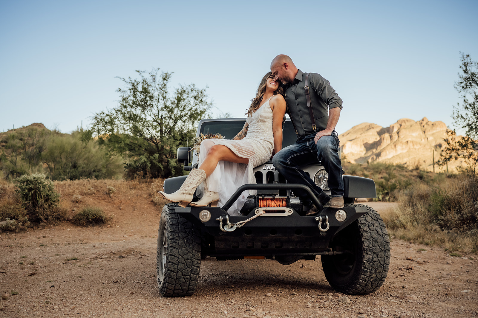 bride and groom sitting on Jeep in Gold Canyon Arizona