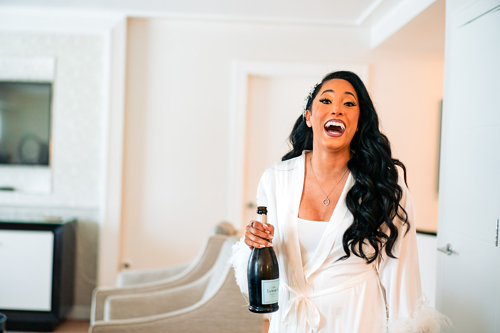 bride opening a bottle of champagne in her hotel room