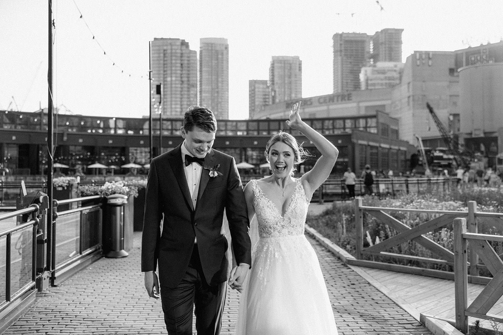 Bride and Groom hold hands and walk the grounds at Steam Whistle Brewing after their wedding ceremony. 