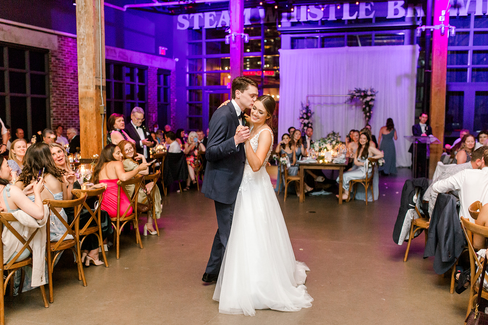 Couple embraces during their first dance at Steam Whistle Brewing, Pilsner Hall