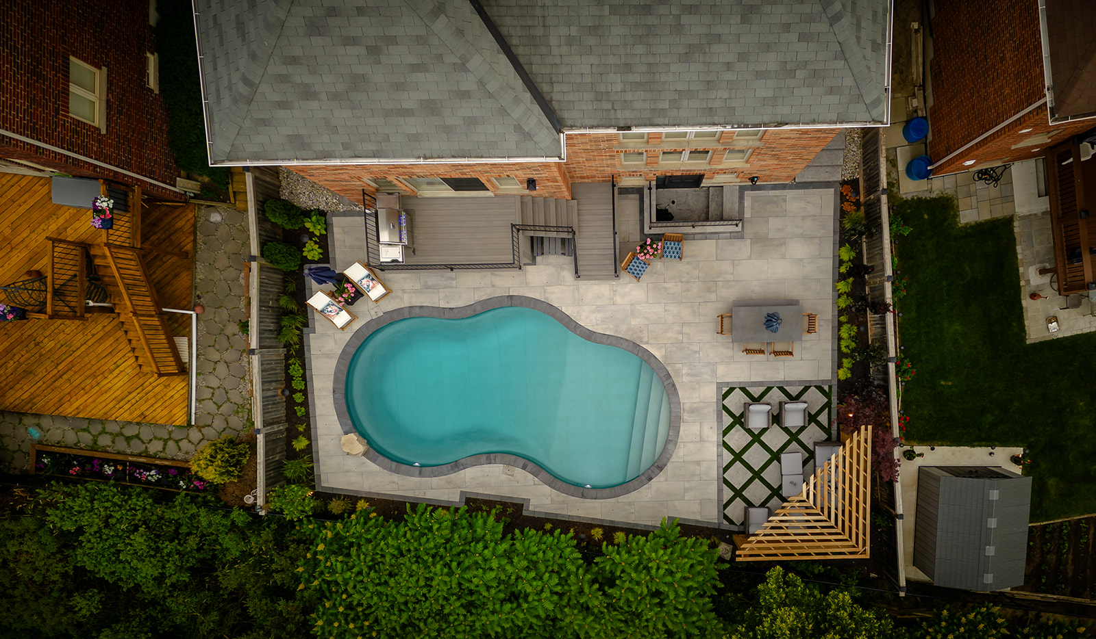Top-down view of a circular pool, outdoor patio set and an outdoor table.
