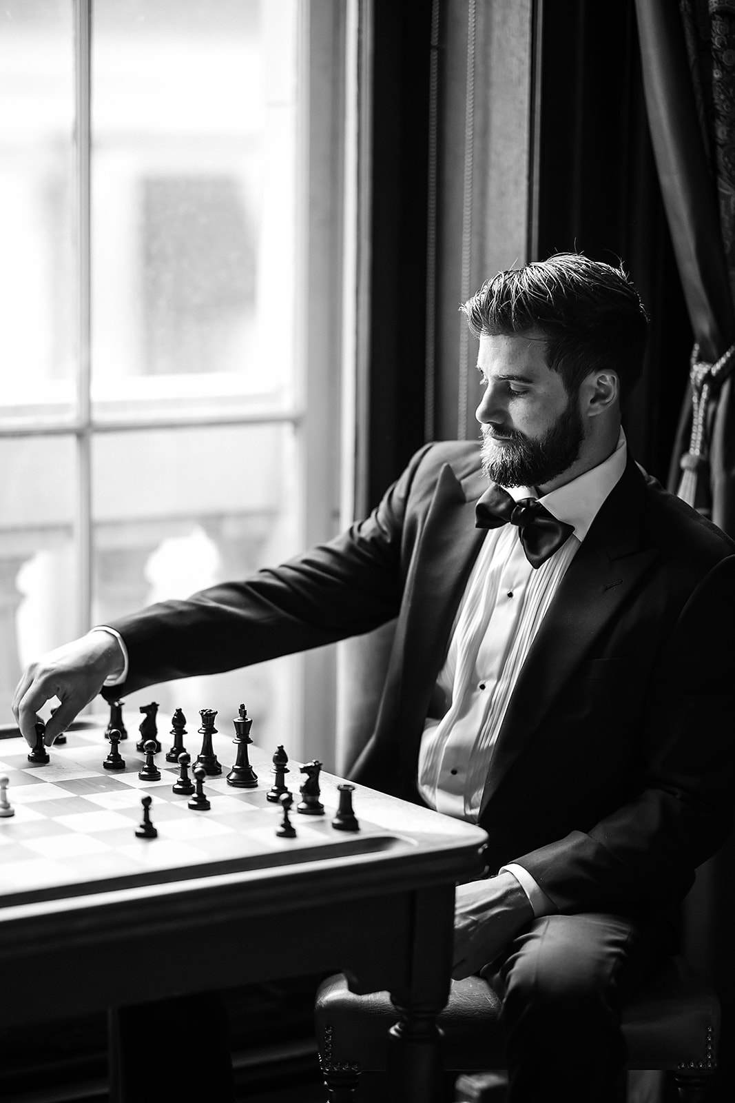 Portrait of the groom playing chess at the Union League Library on his wedding day in Philadelphia