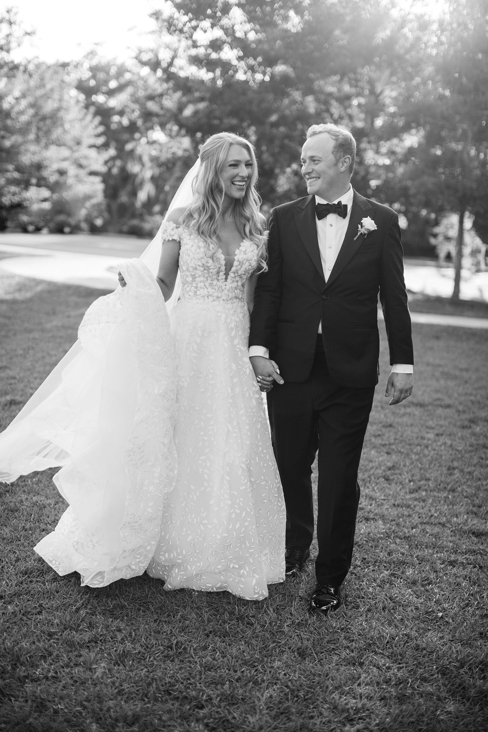 black and white image of bride and groom walking
