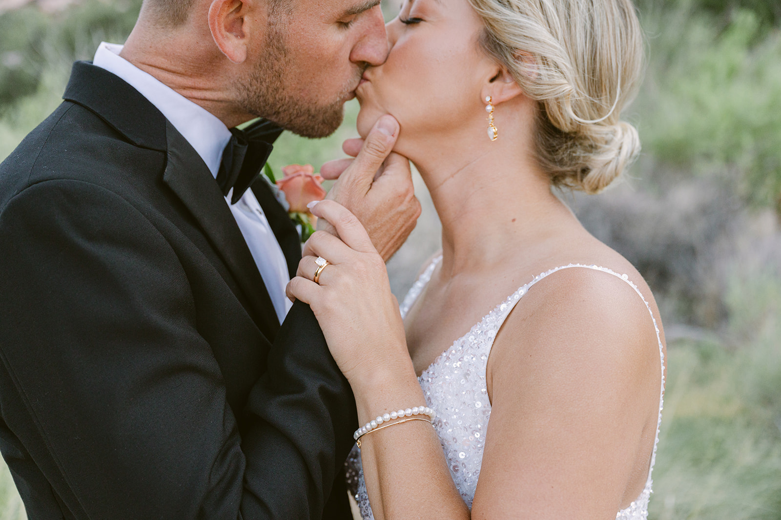 groom holding brides chin for a close up of diamond wedding ring