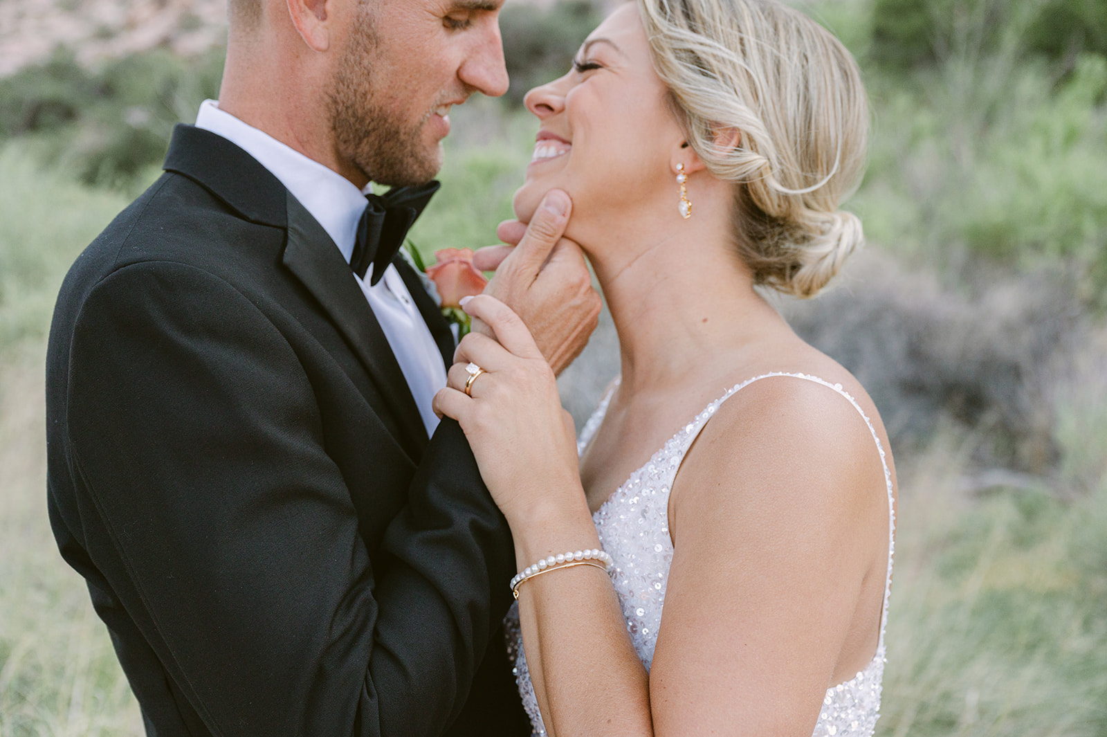 groom holding brides chin for a close up of diamond wedding ring