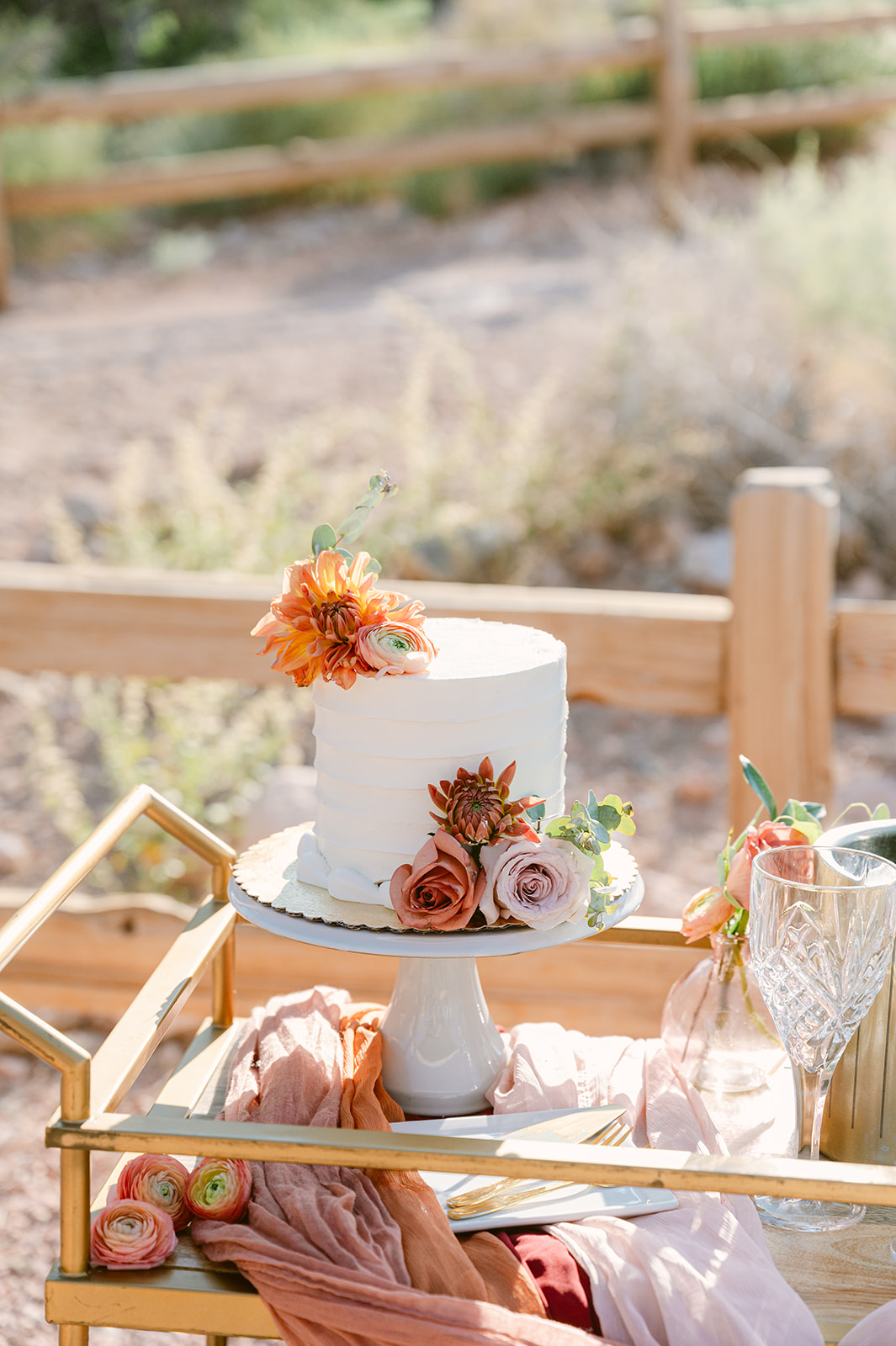 wedding cake with pops of burnt orange and blush flowers