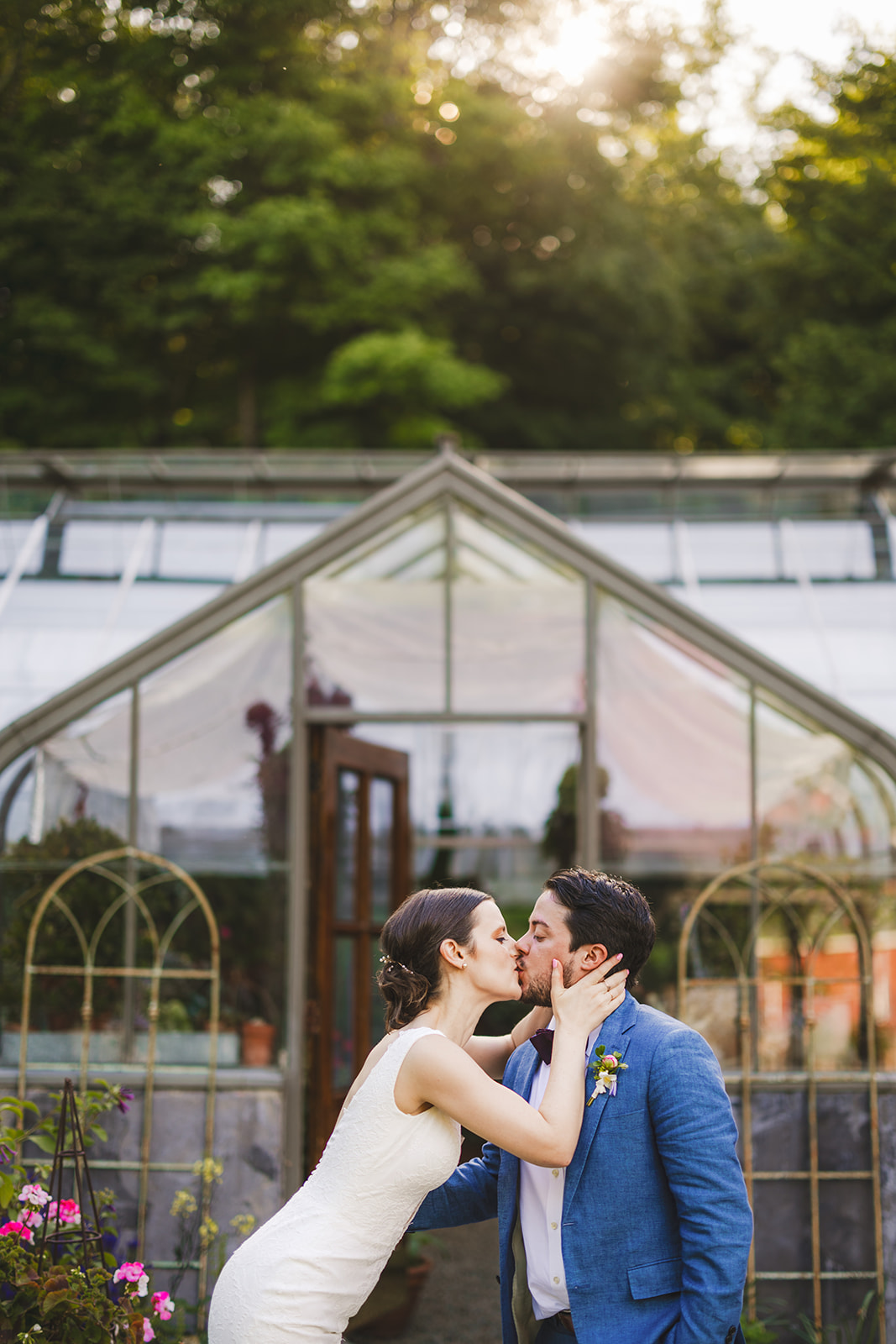 bride and groom kissing outside of a greenhouse