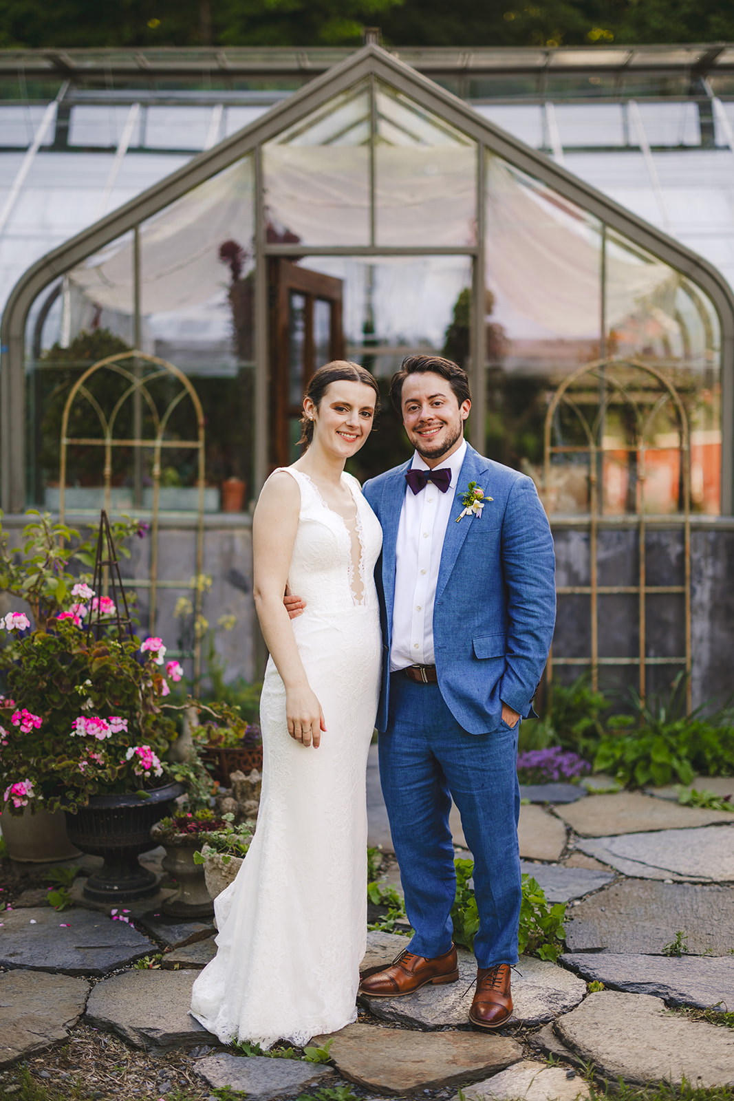bride and groom standing together outside of a greenhouse