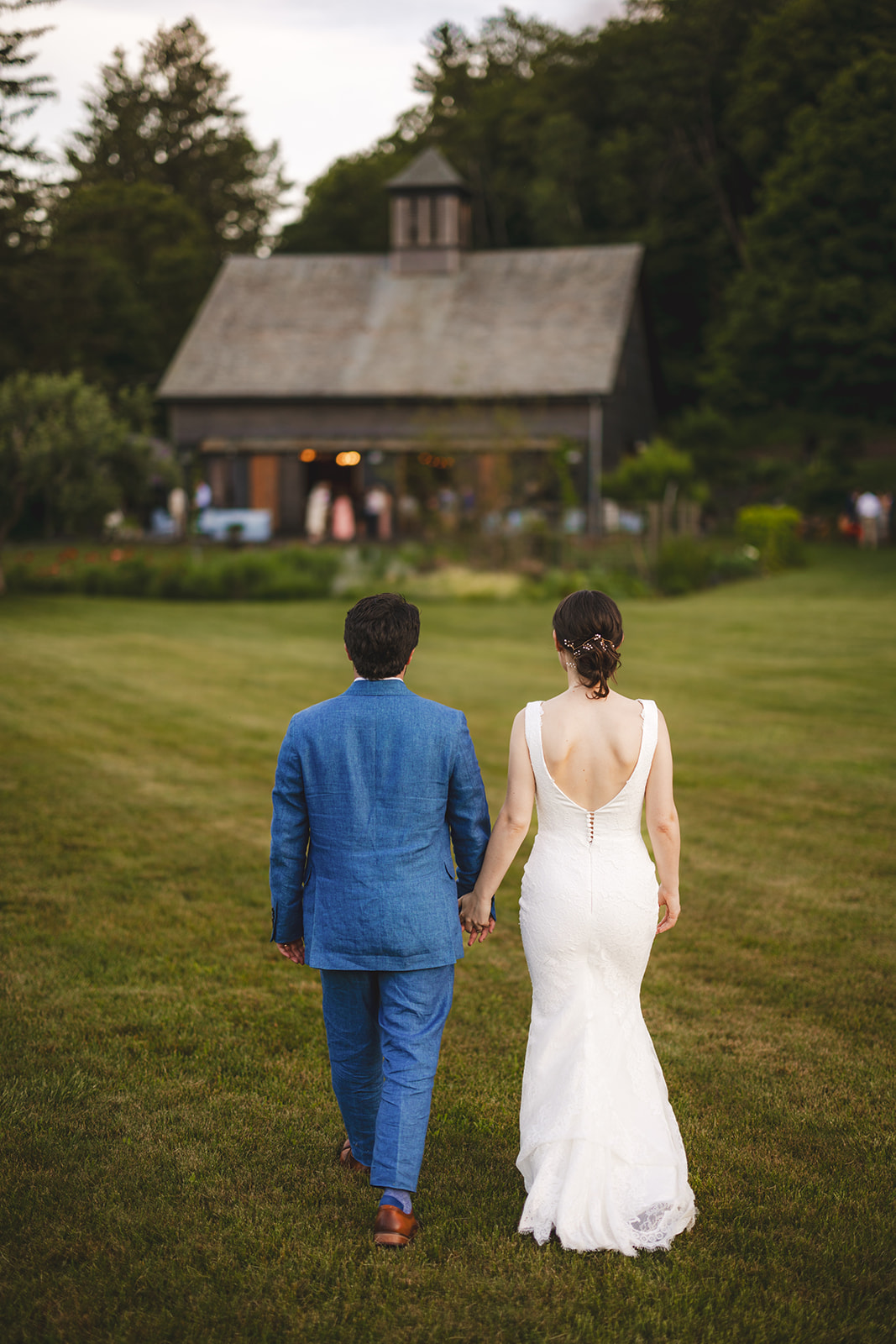 bride and groom walking to wedding reception in a rustic barn at Gloriosa & Co. in Ashfield 
