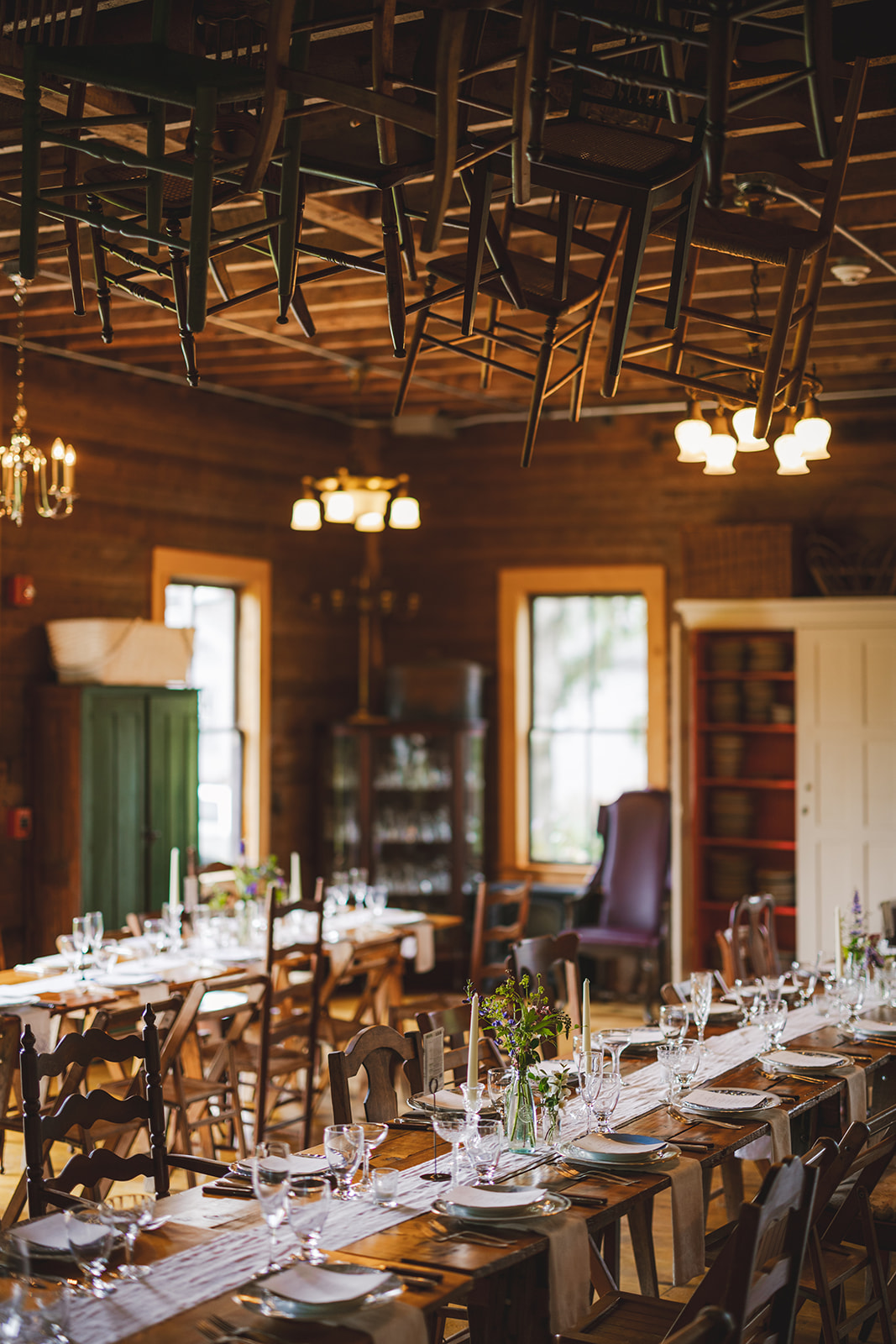 a wedding reception table with chairs hanging from the ceiling in the barn at Gloriosa & Co. Wedding, Ashfield, MA