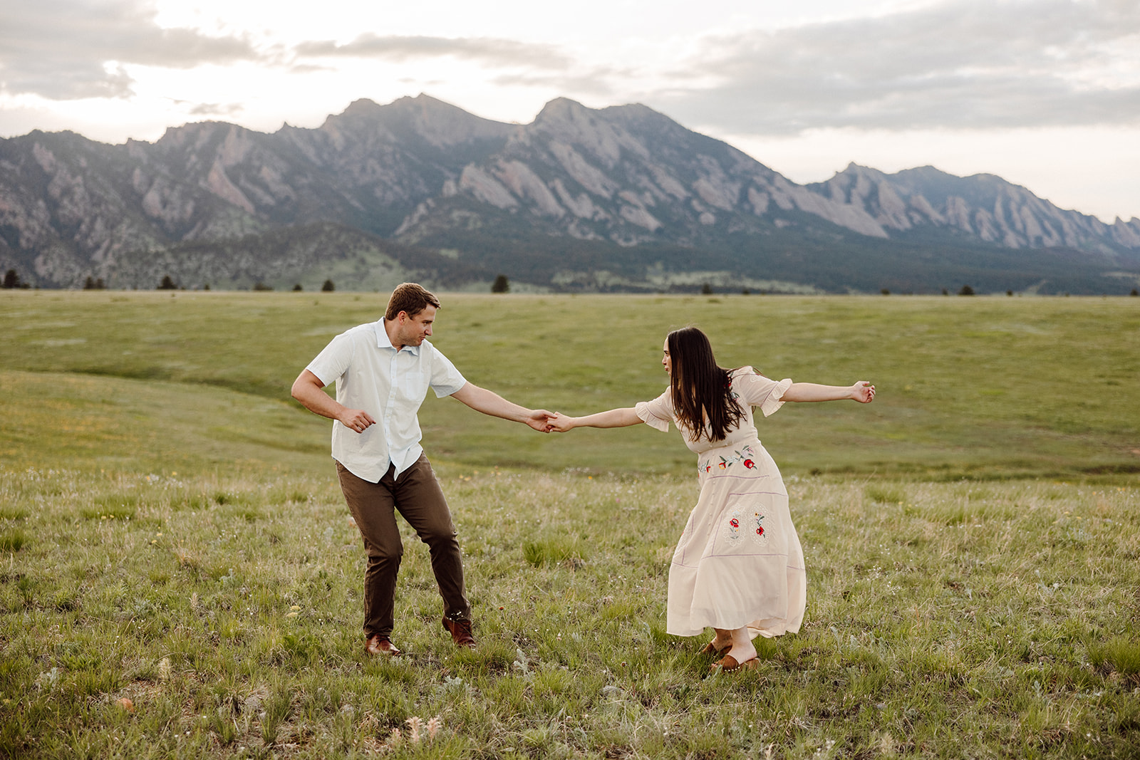 Joyous couple dancing near the mountains during their Denver engagement photo session