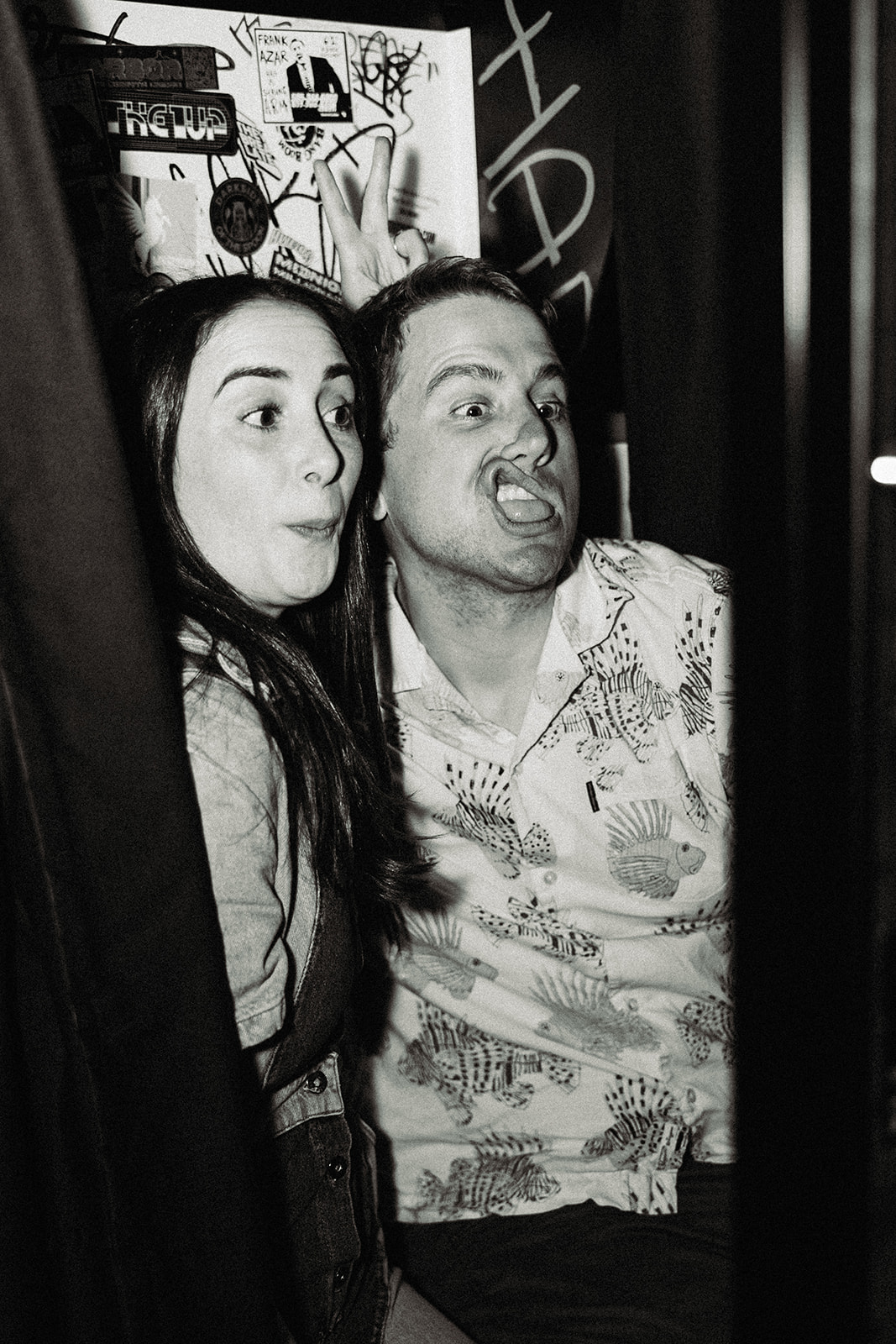 Engaged couple making silly faces for the arcade photo booth