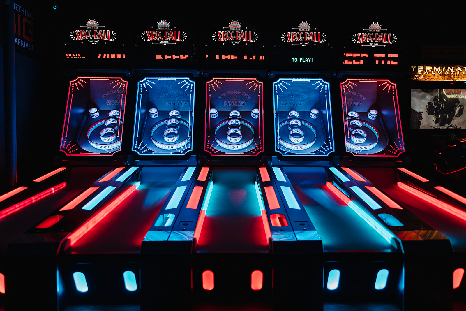 The skee ball games glowing with red and blue lights in this indoor Denver arcade