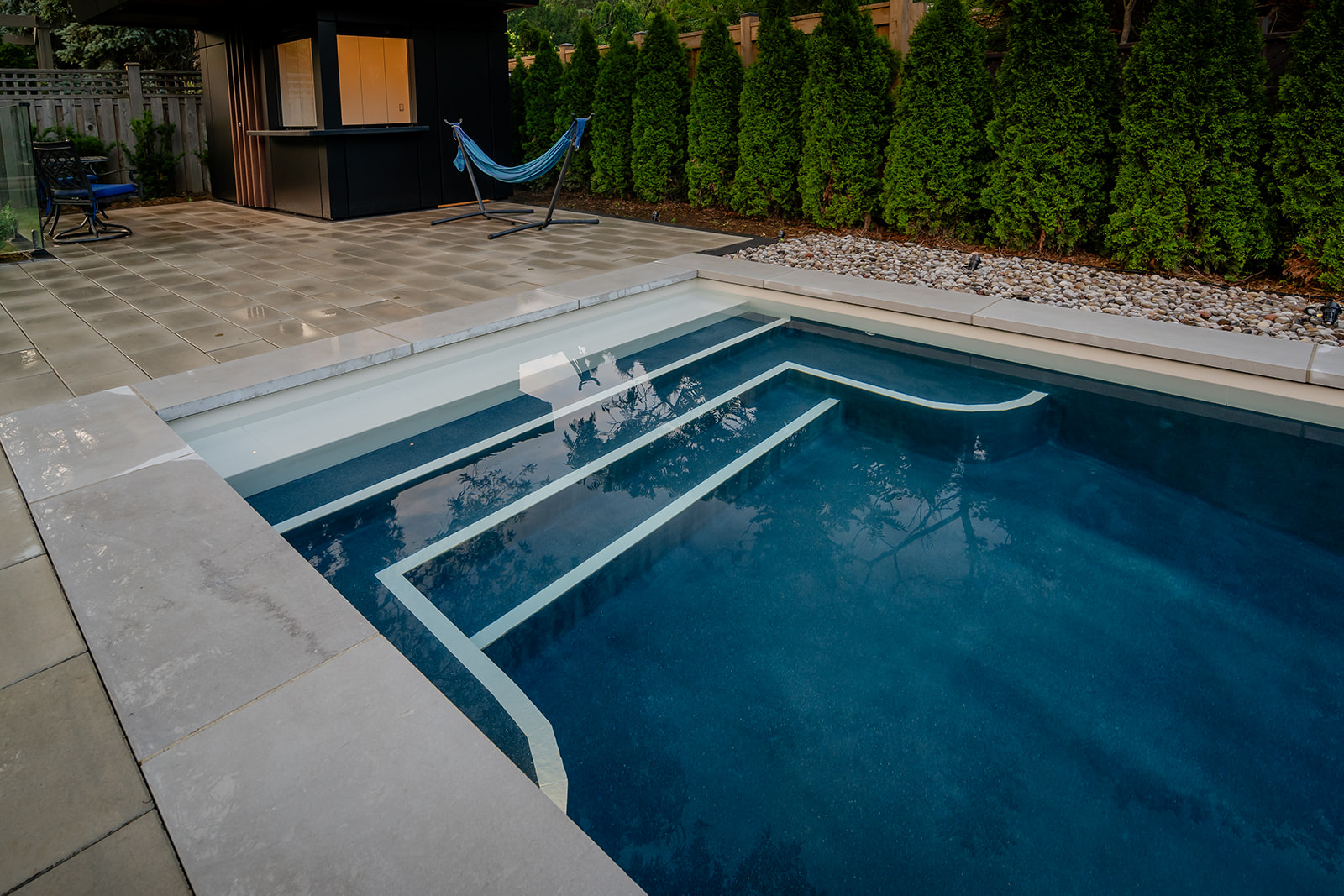An inground pool with steps leading into it.