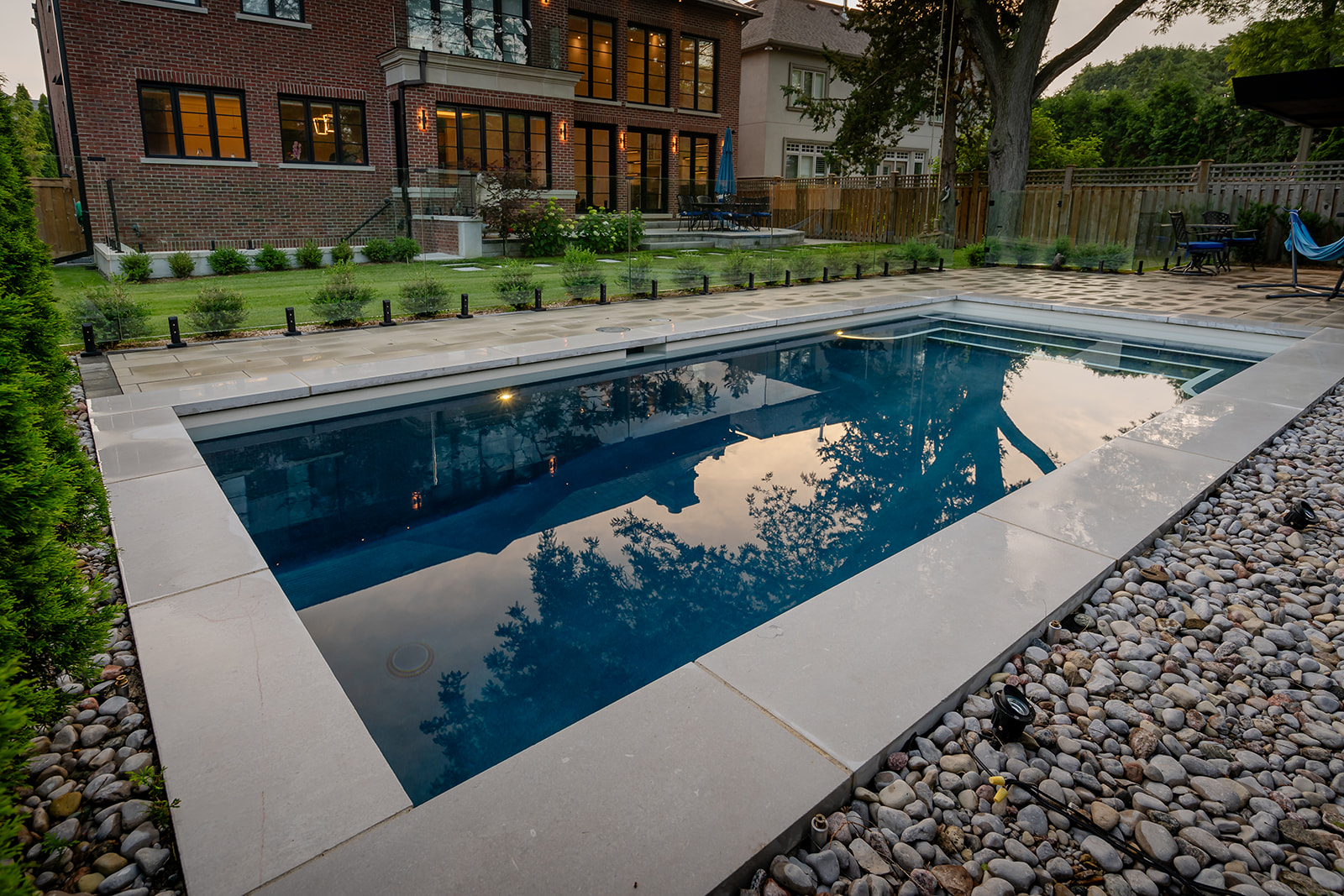 An inground pool surrounded by patio.