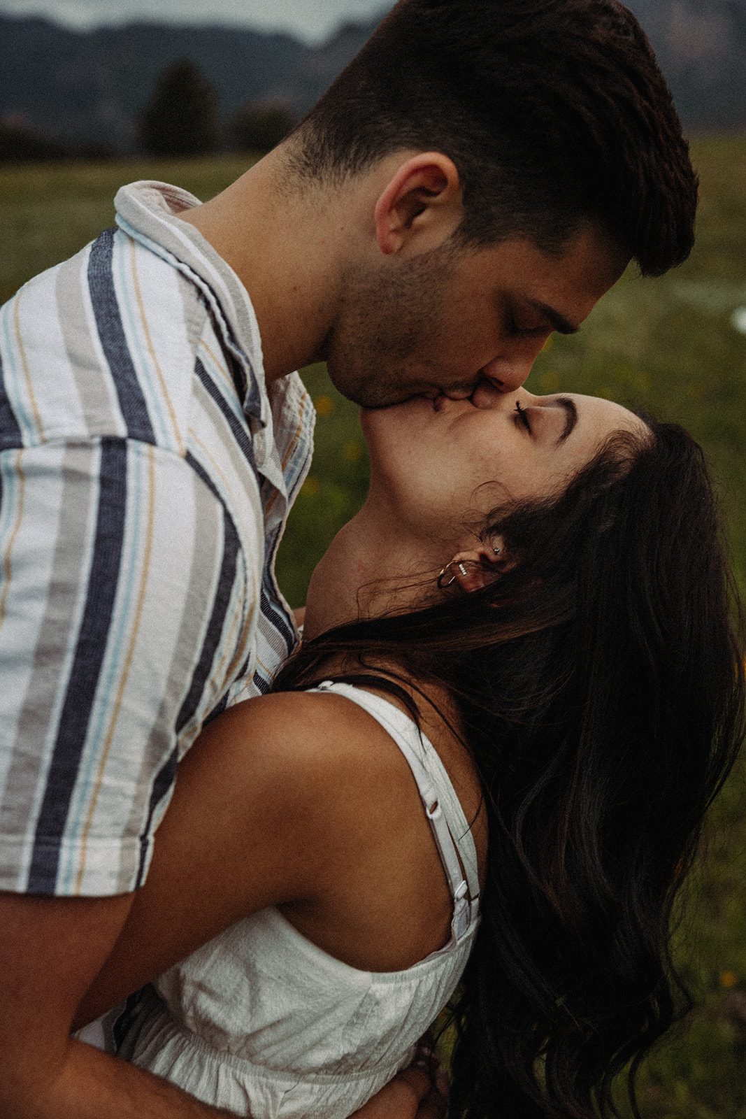 A man and woman kissing during their Colorado mountain engagement session 