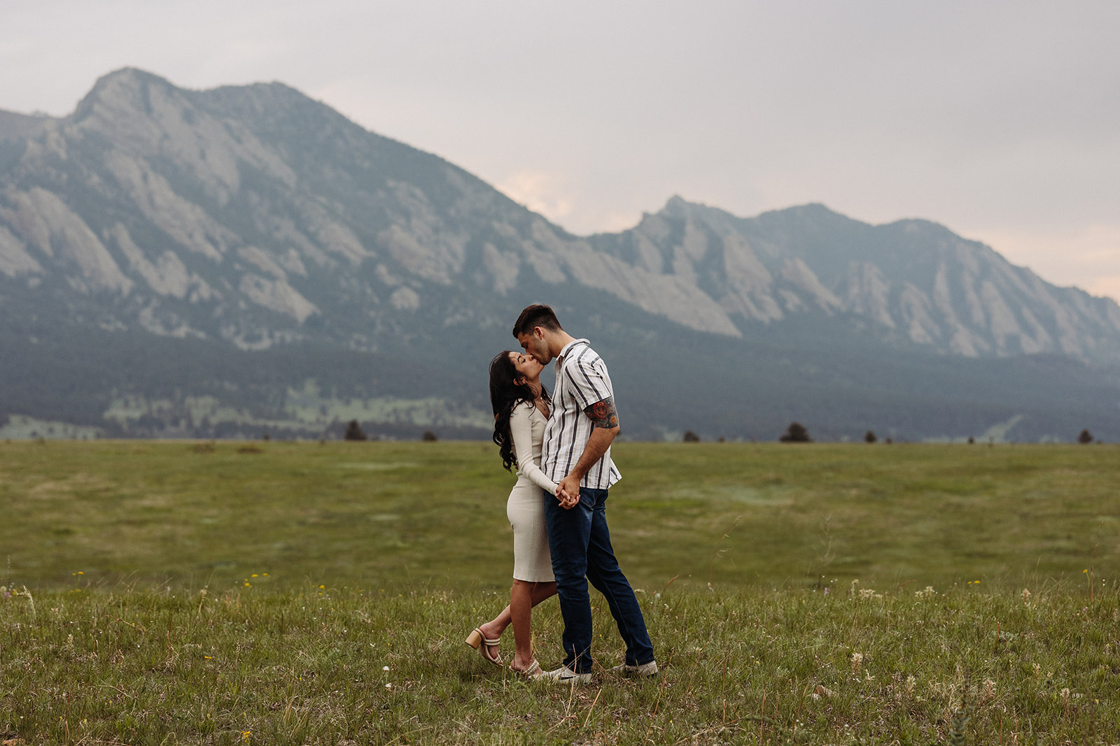 A man and woman kissing during their Colorado mountain engagement session 