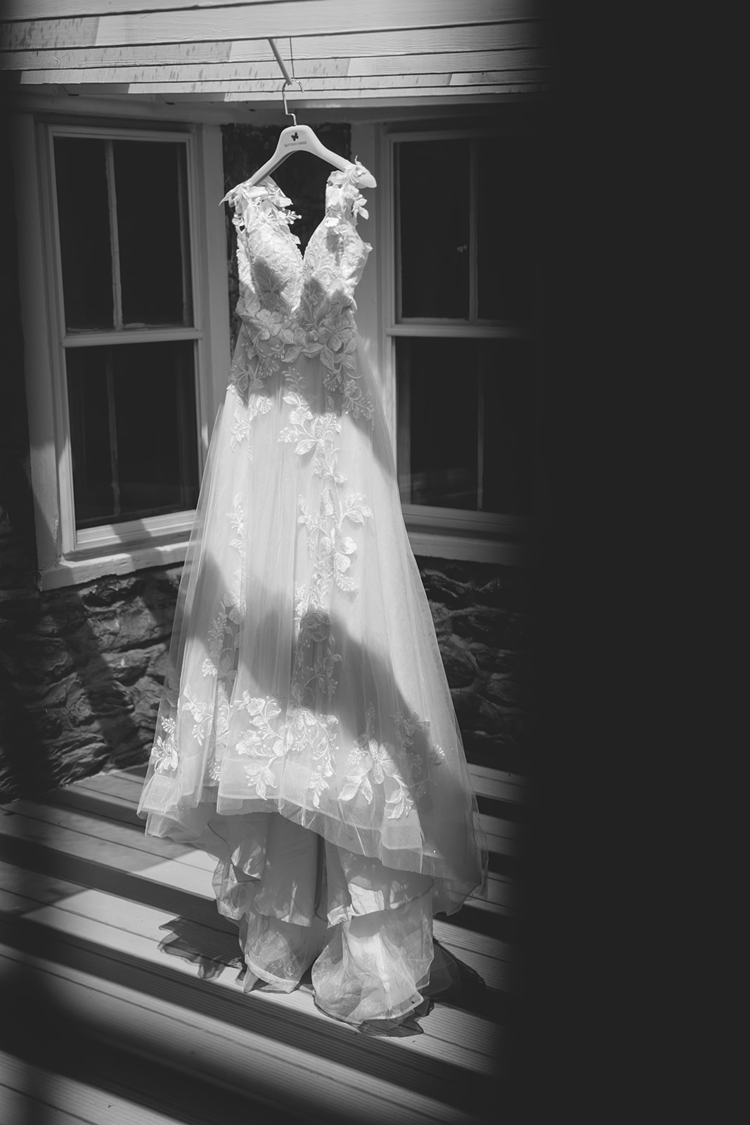The wedding dress hangs on the balcony in dramatic shadows
