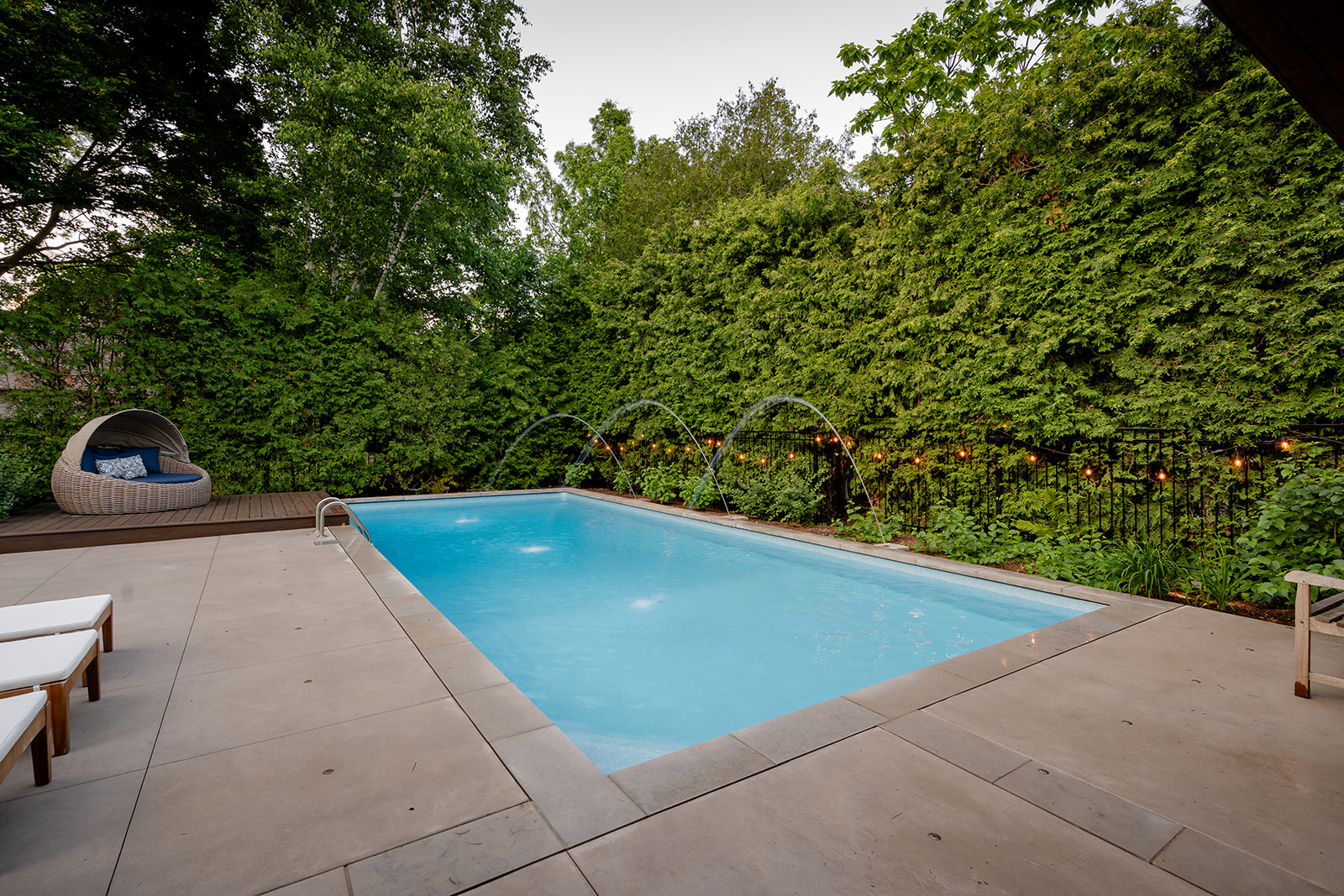 An inground pool with a seating area in the corner.