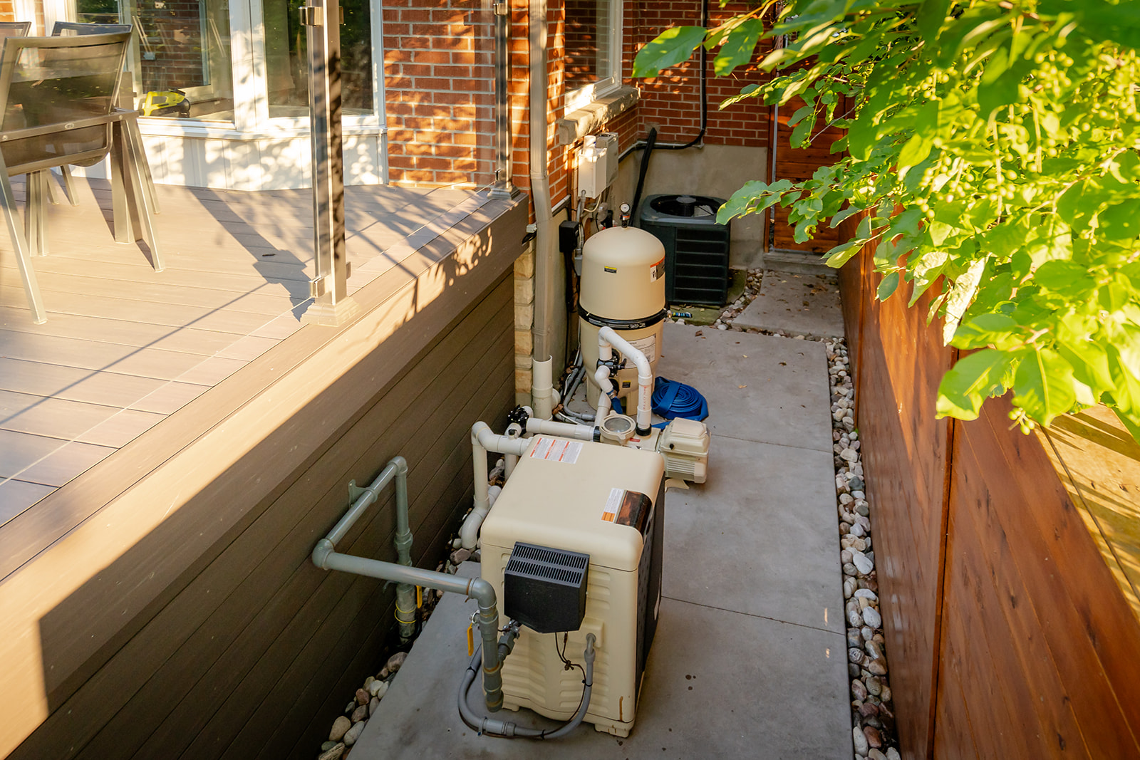 Pool pumps lined up beside a deck outside.