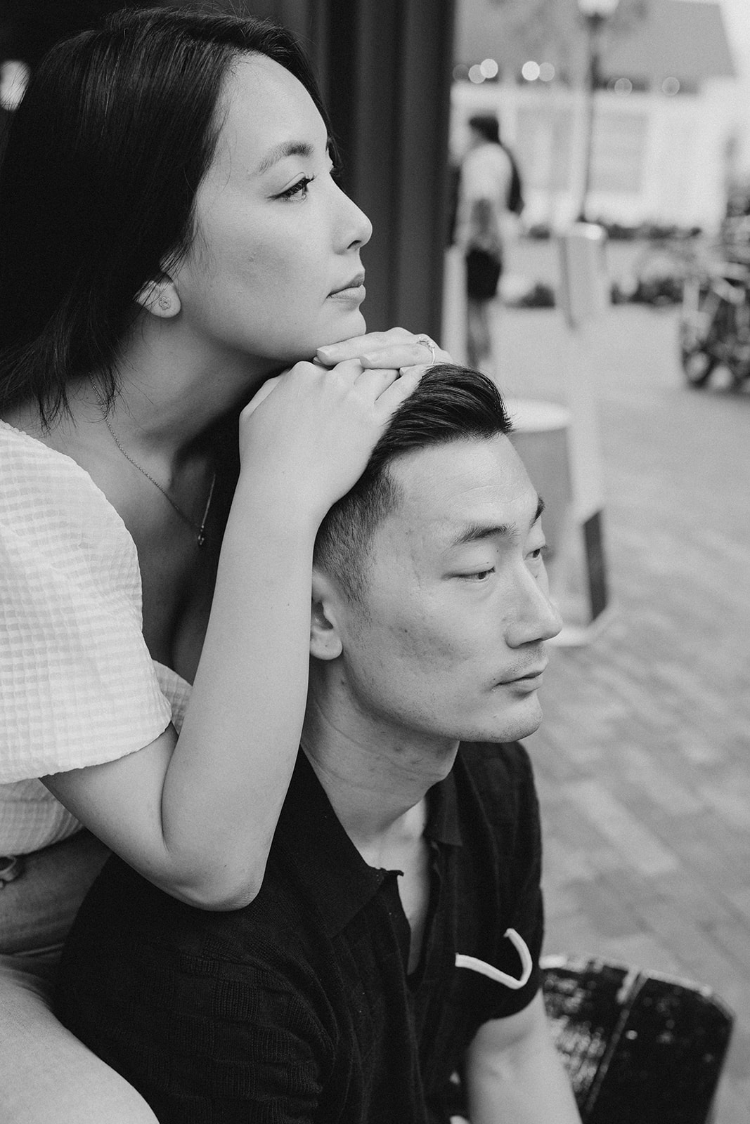 black and white photo of couple, with girl's chin and hands on top of guy's head