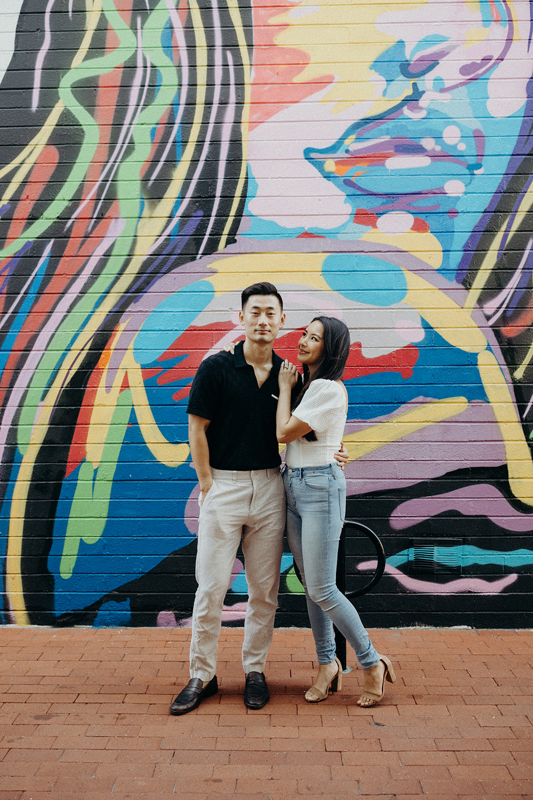 couple standing in front of colorful wall