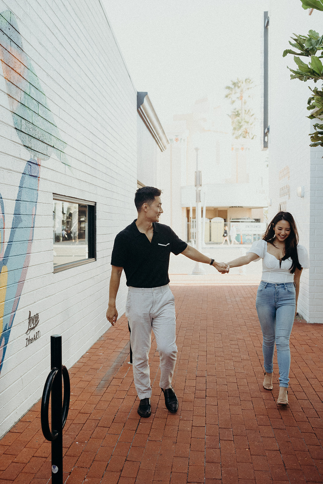 couple walking hand in hand in alley