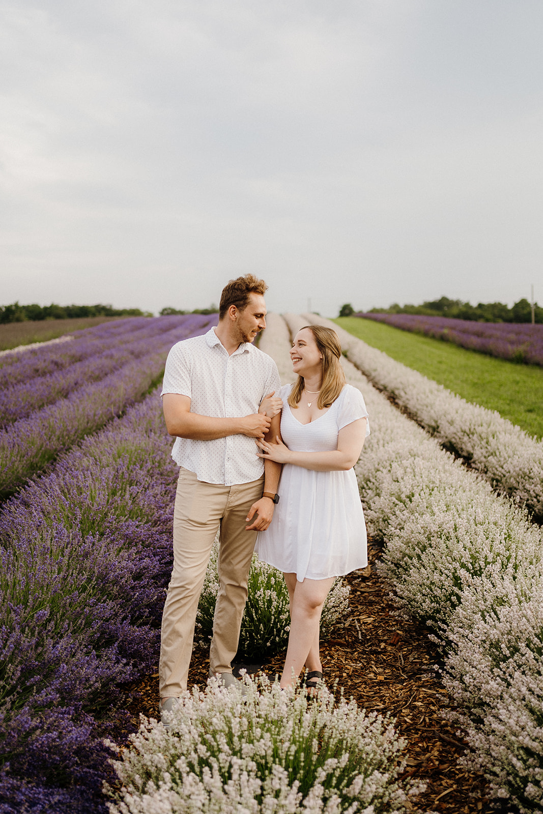 Man and woman standing beside each other next to lavender.