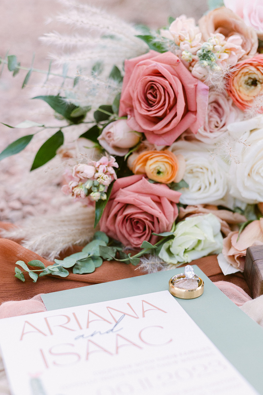 peach, yellow and blush wedding florals with displayed with wedding invitation and ring wedding flat lay