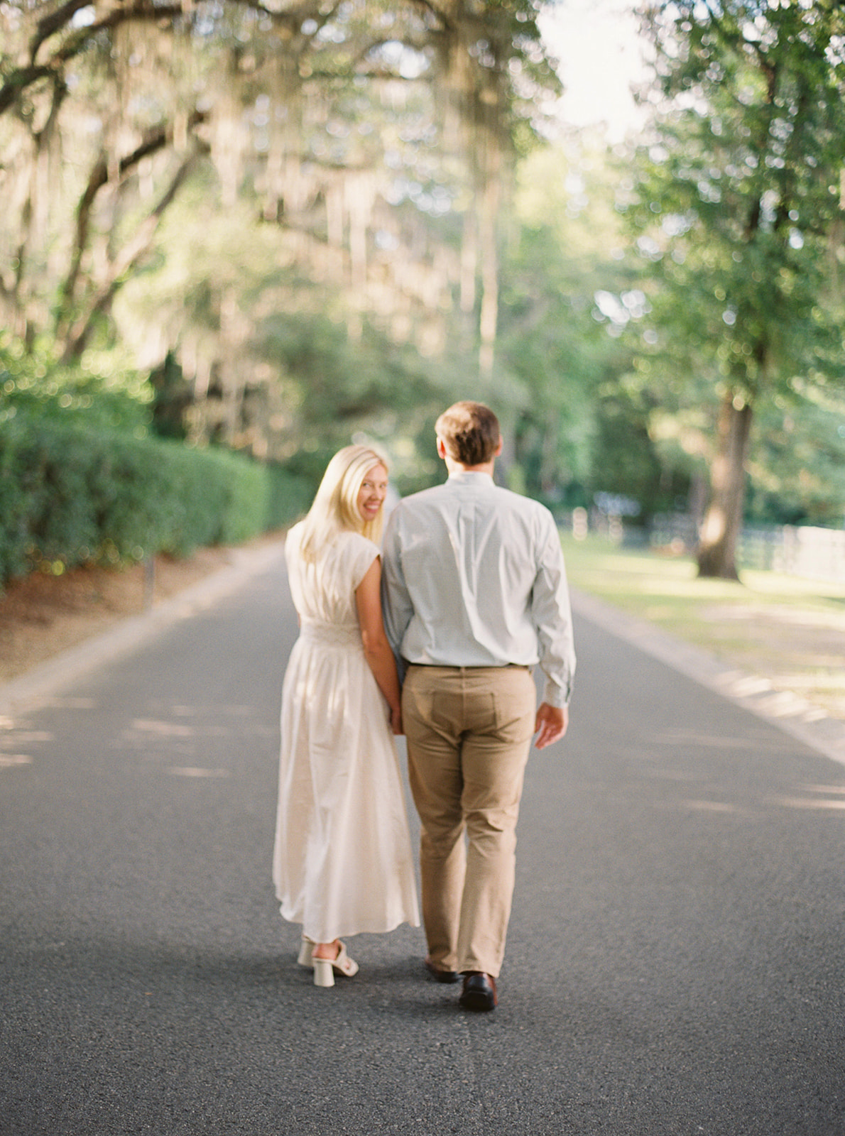 Engagement Session couple walking on street in near horses during golden hour in Thomasville, Georgia. Contax645