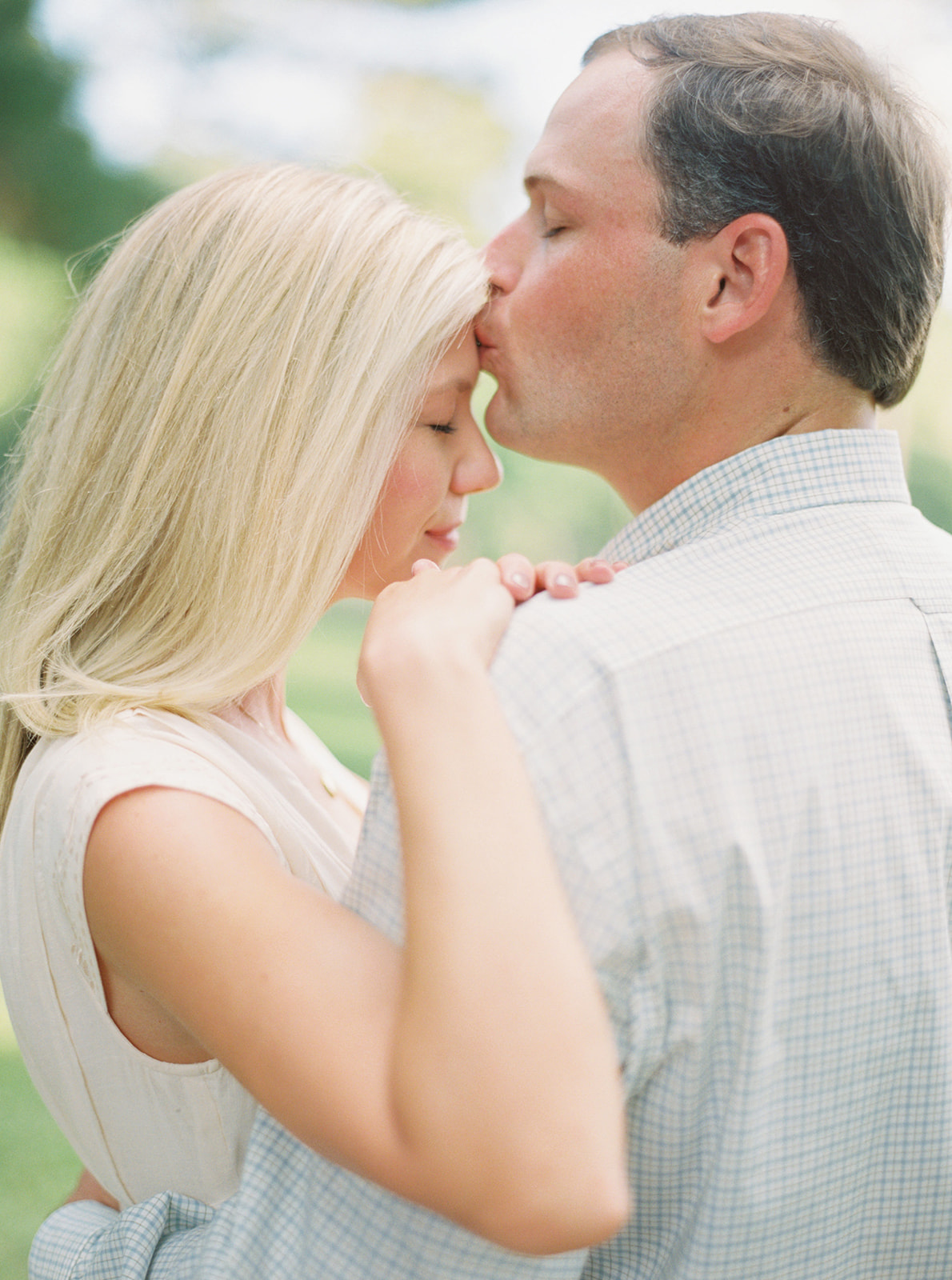 Engagement Session couple kissing on forehead during golden hour in Thomasville, Georgia. Film using Contax645