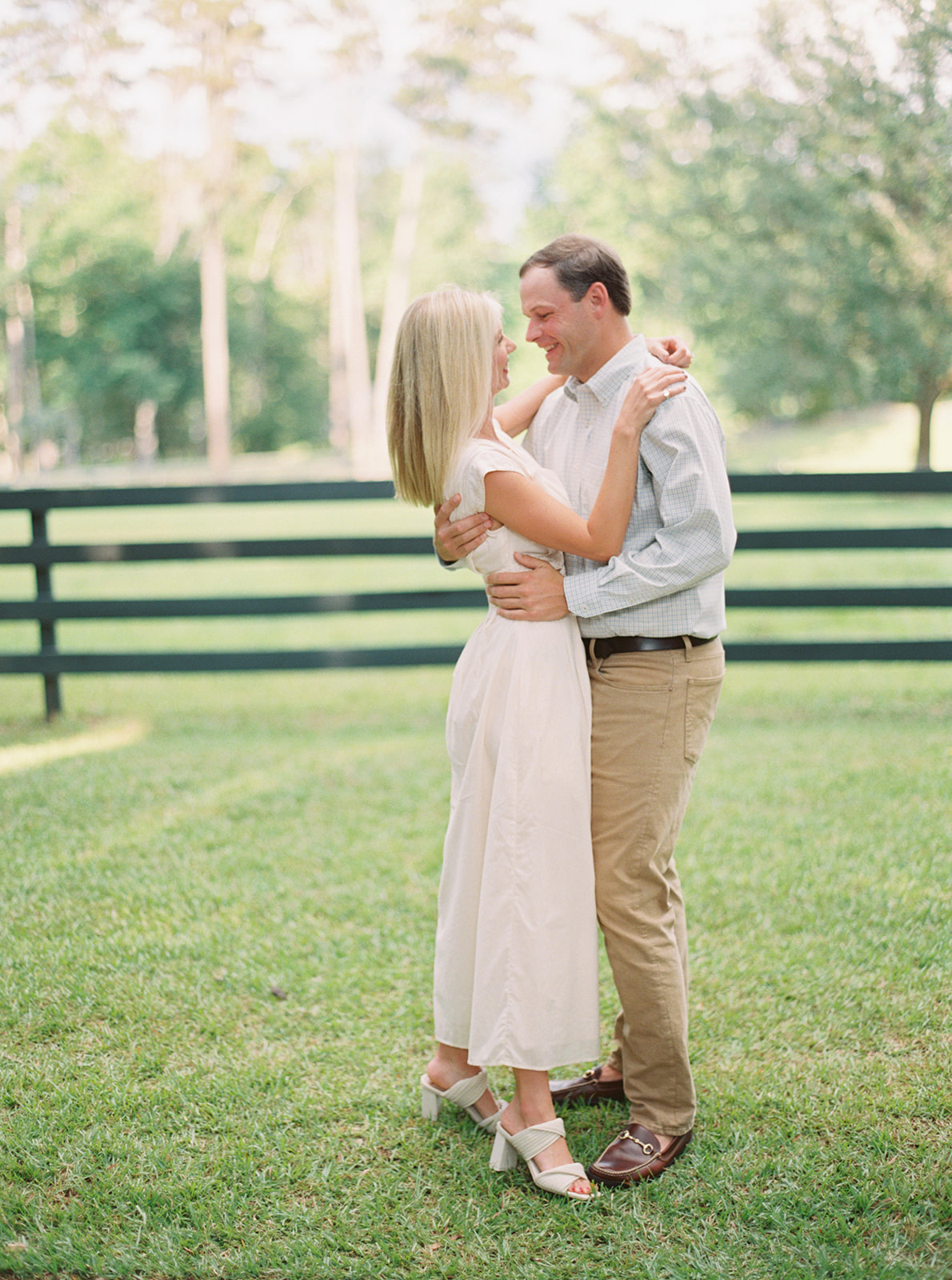 Engagement Session couple walking on street in near horses during golden hour in Thomasville, GA