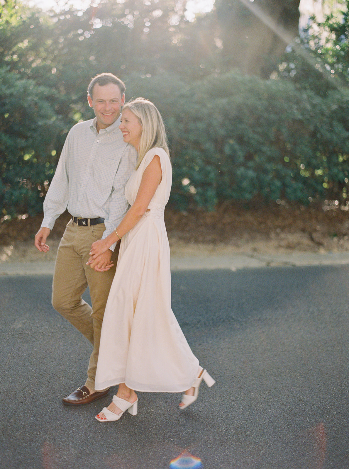 Engagement Session couple walking on street in near horses during golden hour in Thomasville, Georgia. Contax645