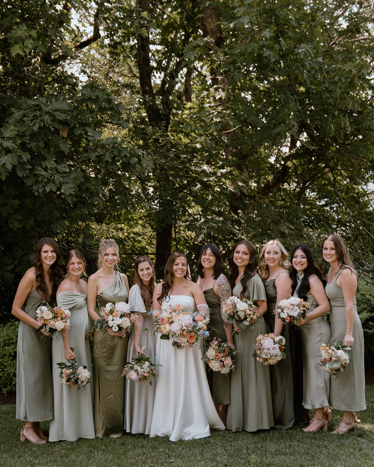 Bride and bridesmaids with mismatched sage green bridesmaid dresses