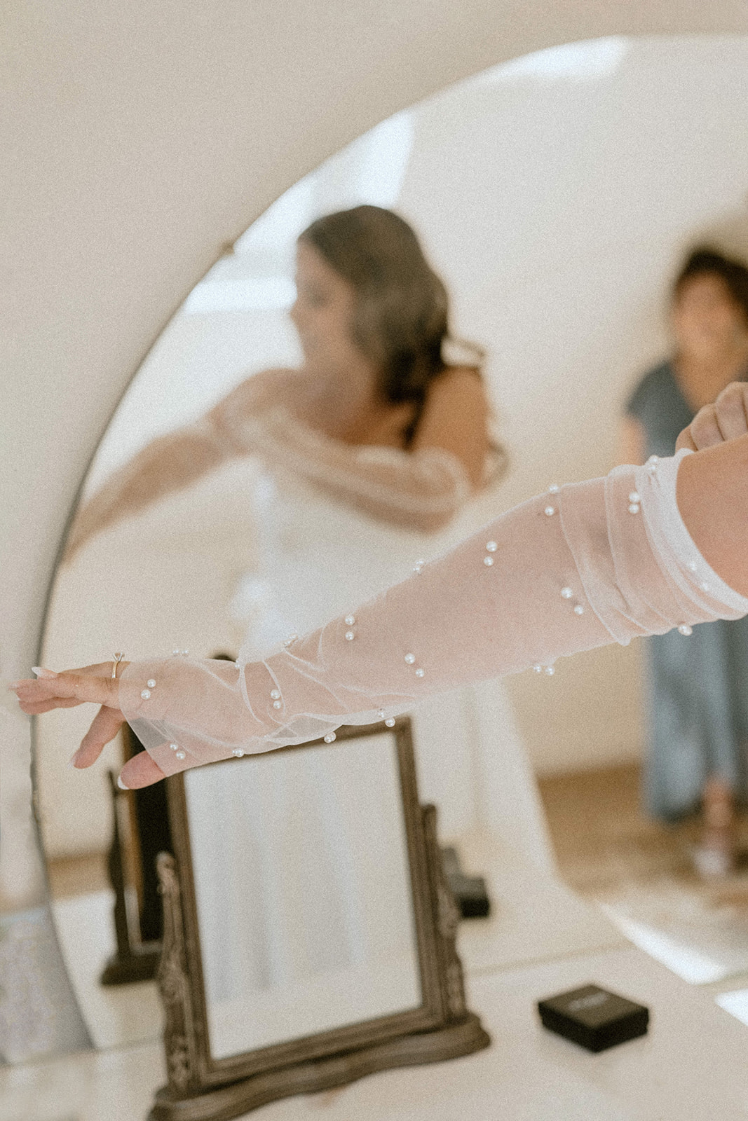 Bride putting on pearl gloves before her wedding