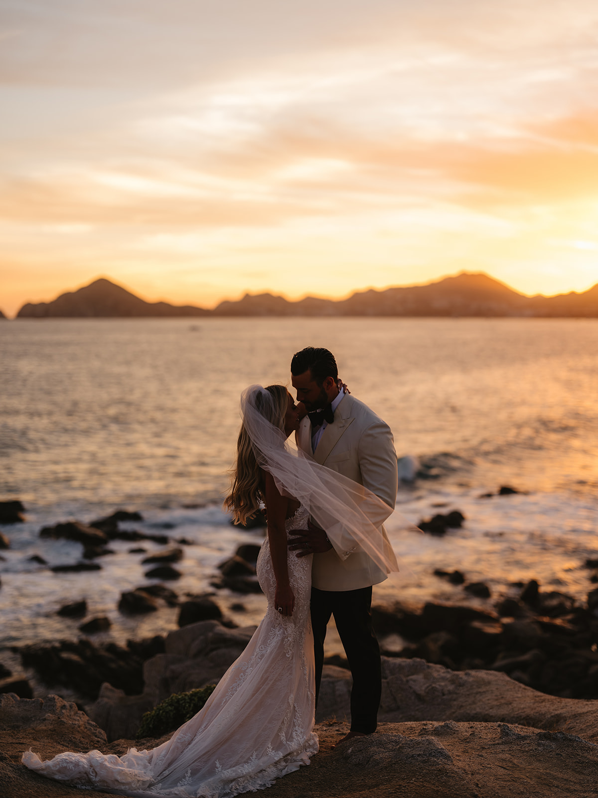 bride and groom at sunset from the cape hotel in cabo, mexico