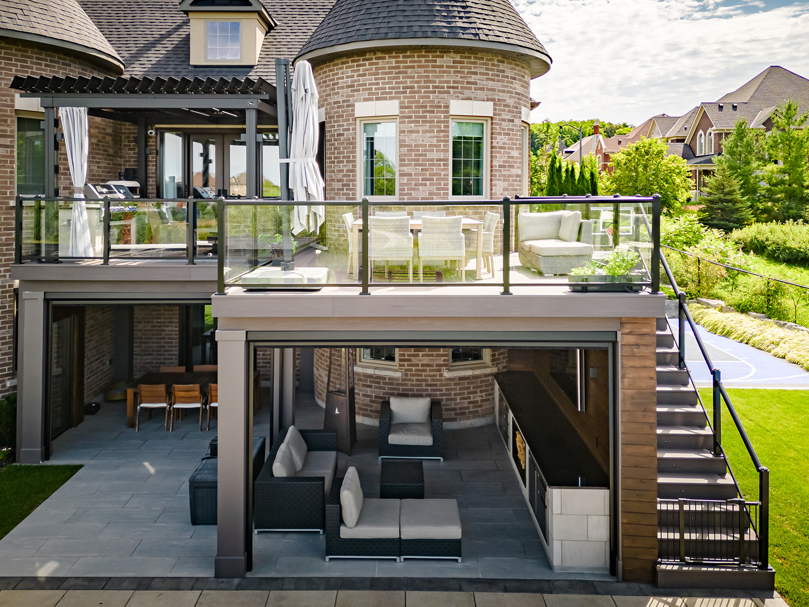 An outdoor patio set on the bottom with a deck overtop with another outdoor patio set and stairs leading up to the deck.