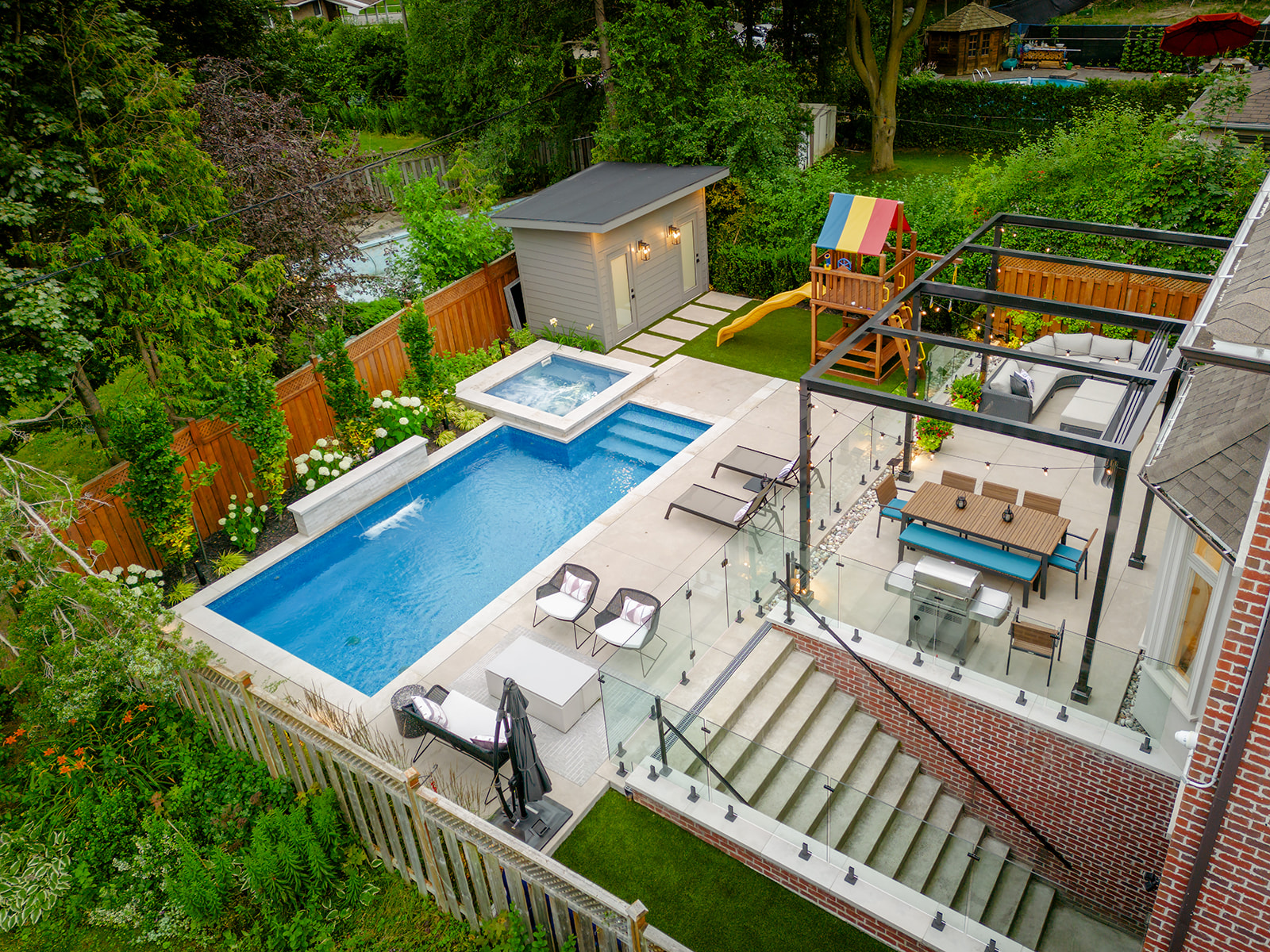 A large backyard with an inground pool and furniture.