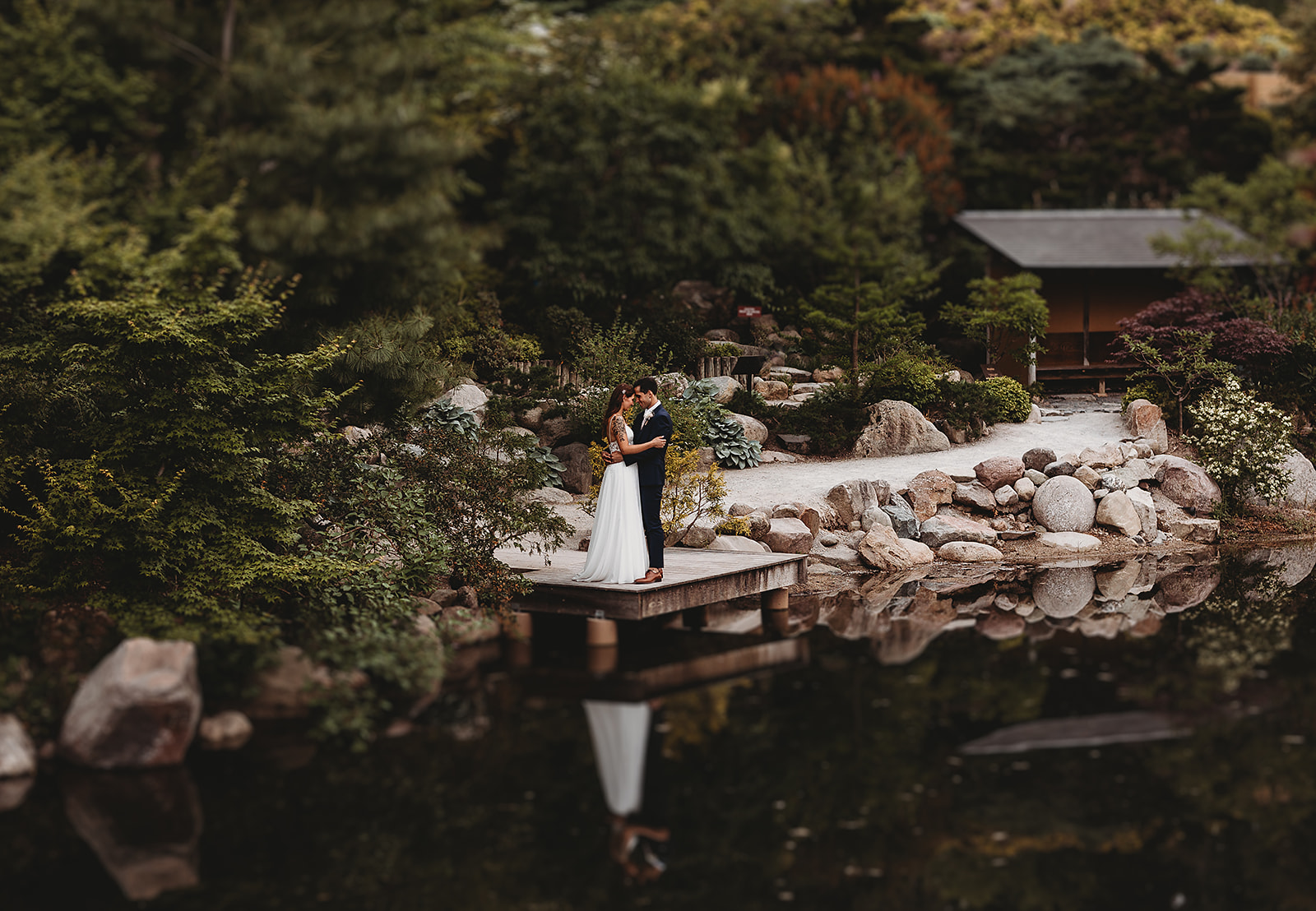 A bride and groom pose for a portrait in the Japanese Garden at Meijer Gardens