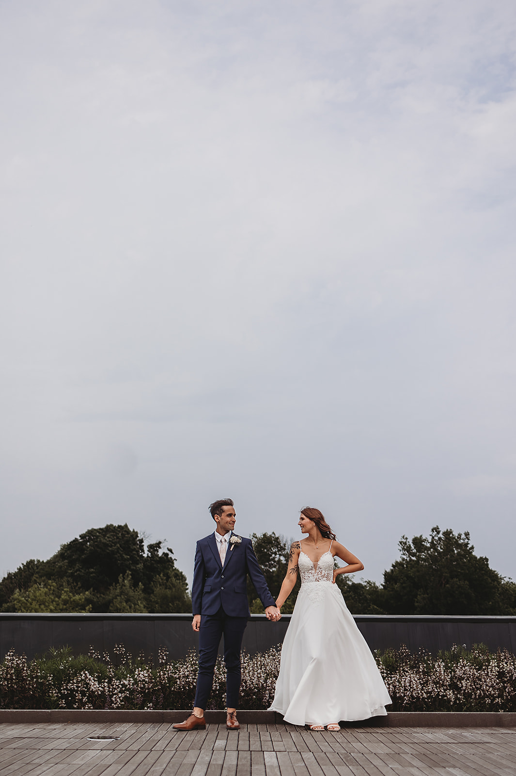 A bride and groom stand atop Padnos Rooftop Garden at their wedding at Frederik Meijer Gardens in Grand Rapids, Michigan