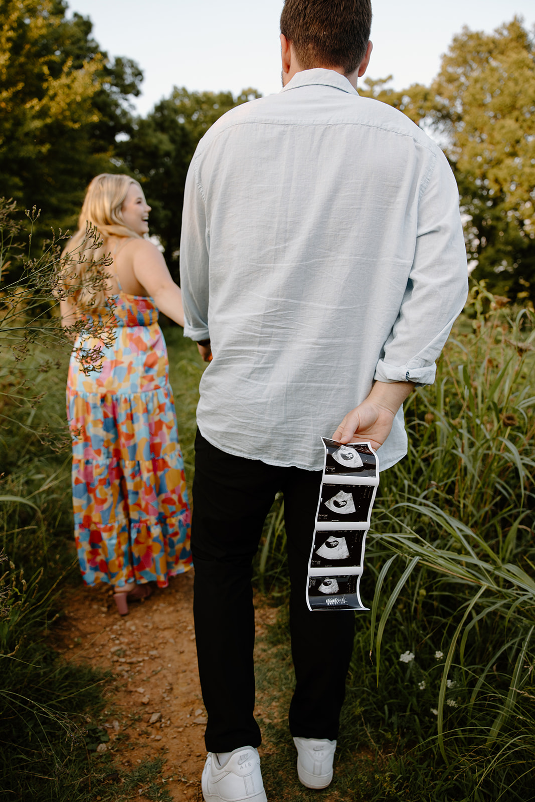 Pregnancy announcement pictures in a field.