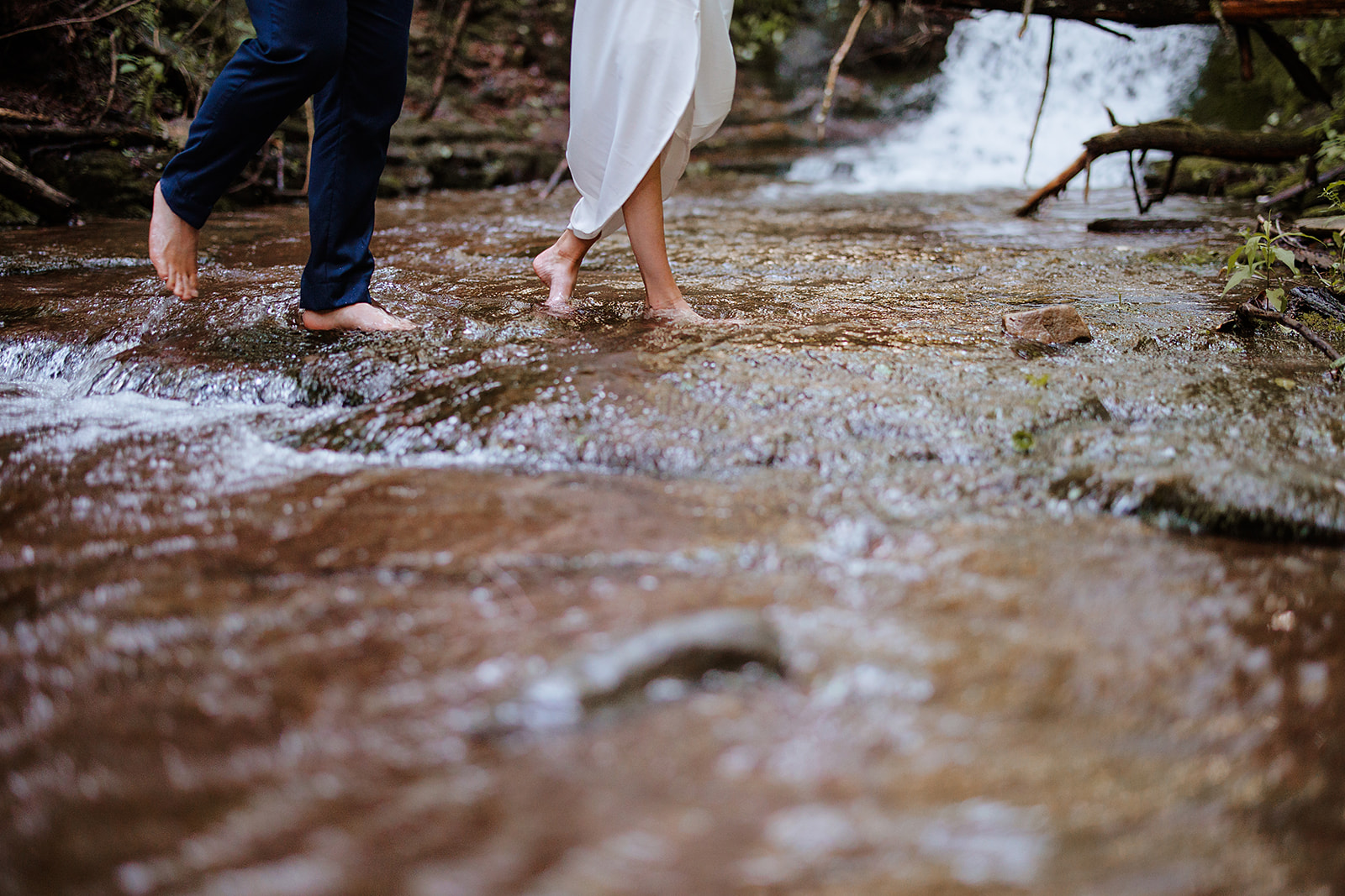 Couple walks through the river barefoot after saying their vows close by at intimate Catskill wedding.