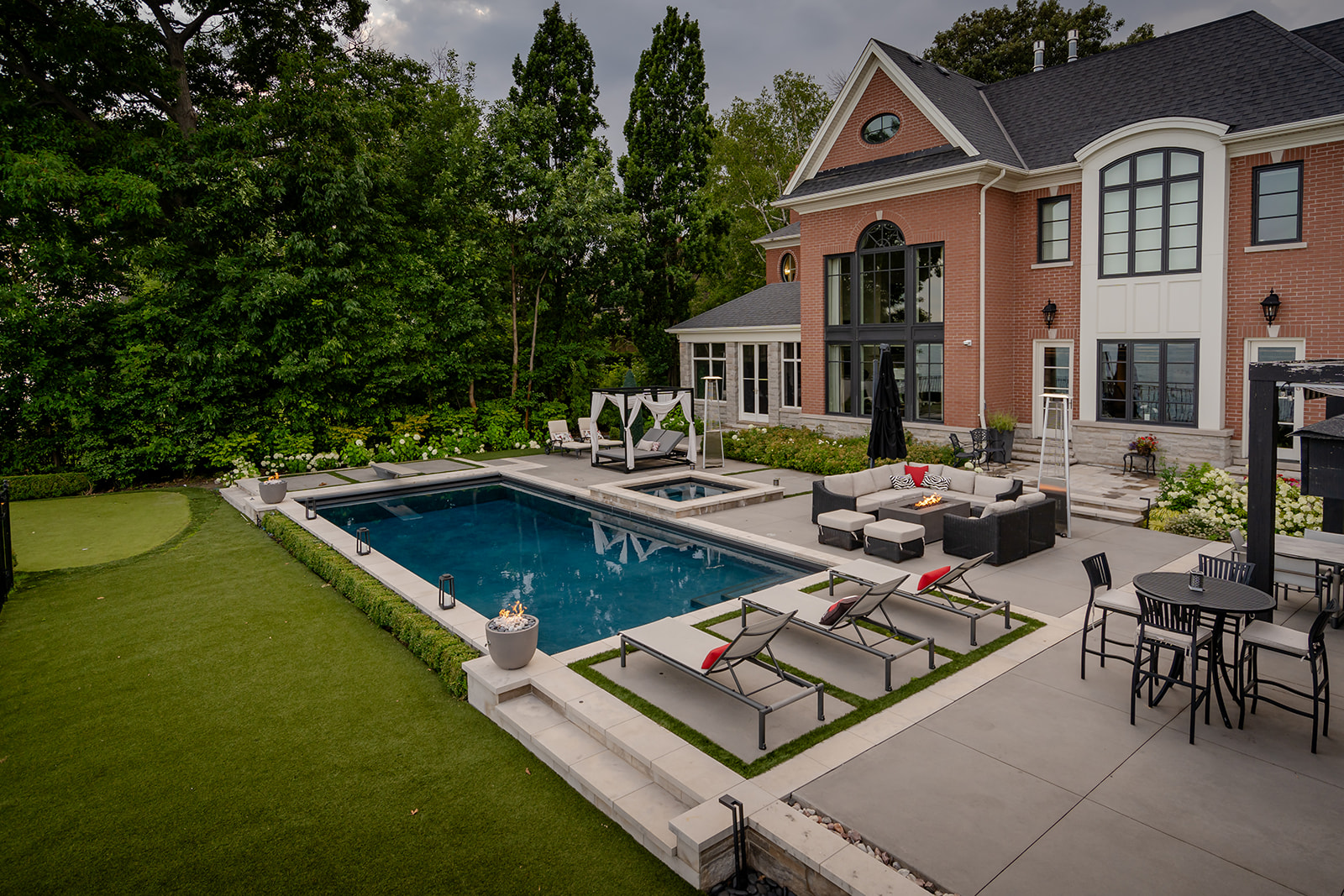 A backyard with an inground pool and a house in the background.