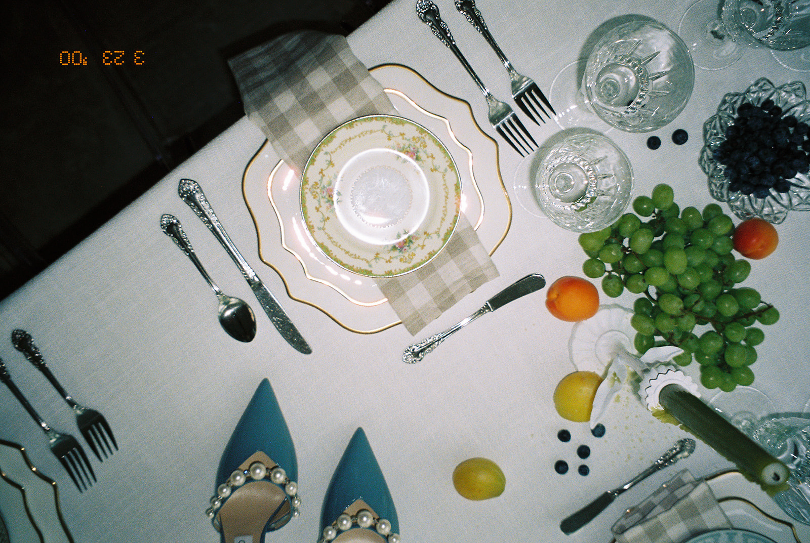 A garden party wedding tablescape captured with film photography showcasing soft color accents and crystal glassware. 