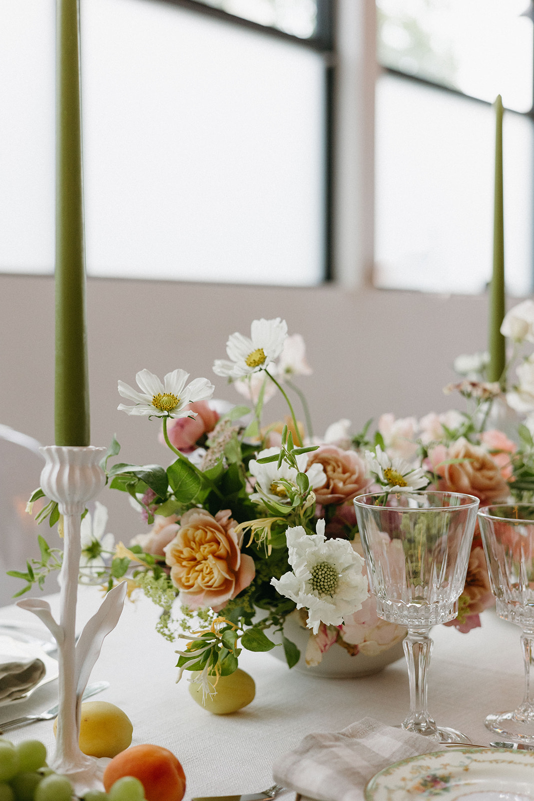 A styled garden party wedding tablescape with a soft color palette, bright florals, and crystal glassware. 