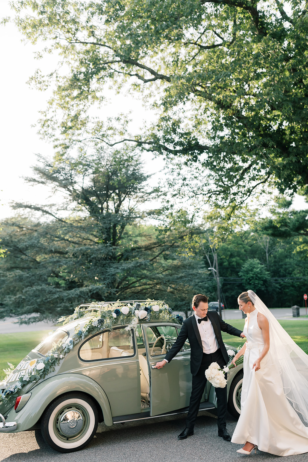 Married couple outside of church for couple's portraits with vintage VW decorated with "just married" sign