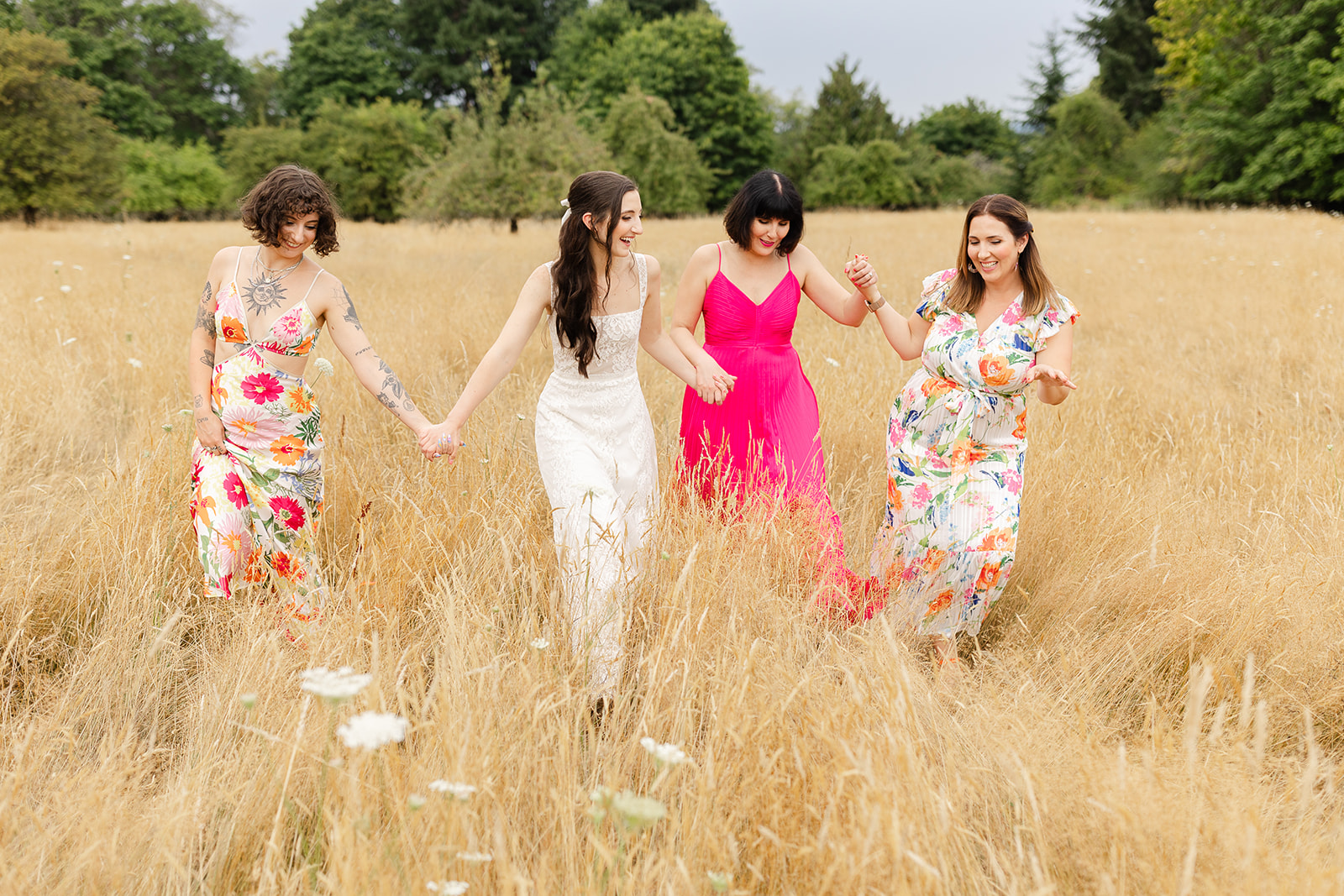 Sisters walking together in a field on a wedding day
