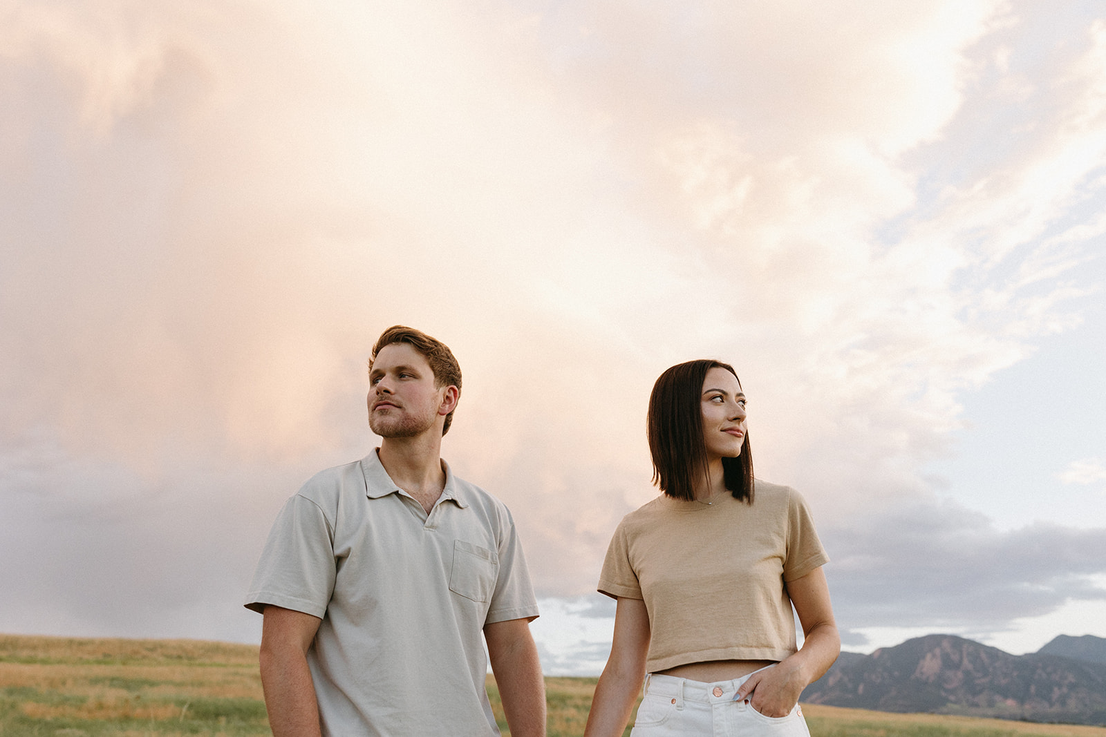 Couples in natural-tone engagement outfits pose for editorial engagement photos at The Flatirons in Boulder.