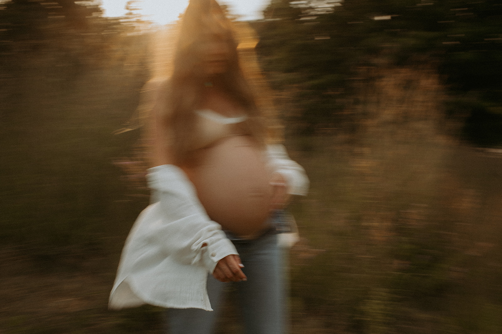 Artistic maternity portrait taken outdoors at sunset by a professional photographer